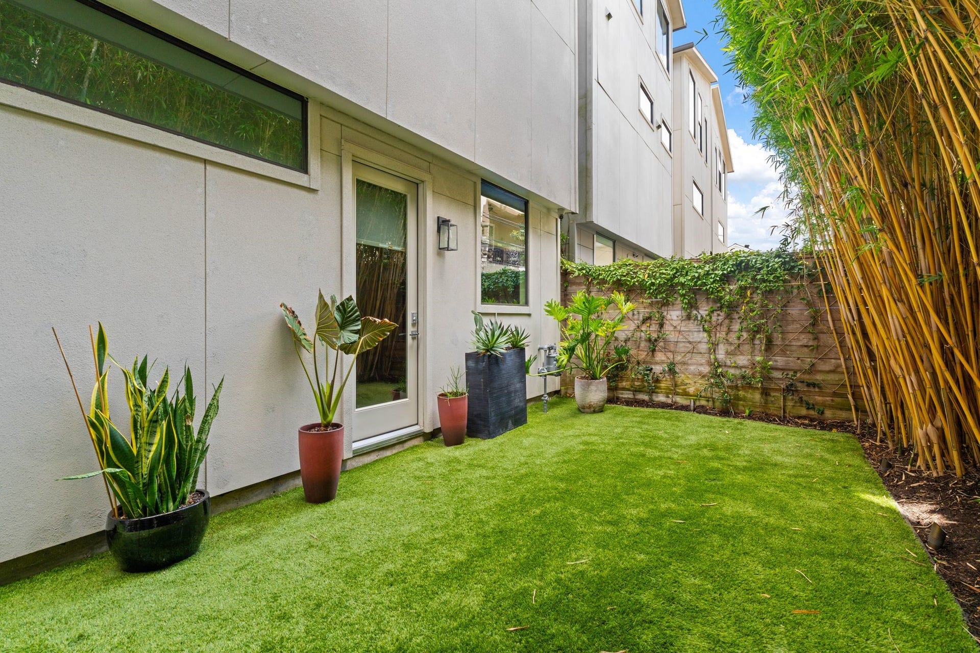 2622 Greenbriar Drive, Houston, TX 77098 Generously sized, low-maintenance backyard features artificial turf, professional landscaping, privacy-enhancing bamboo, and direct access from a first-floor bedroom.