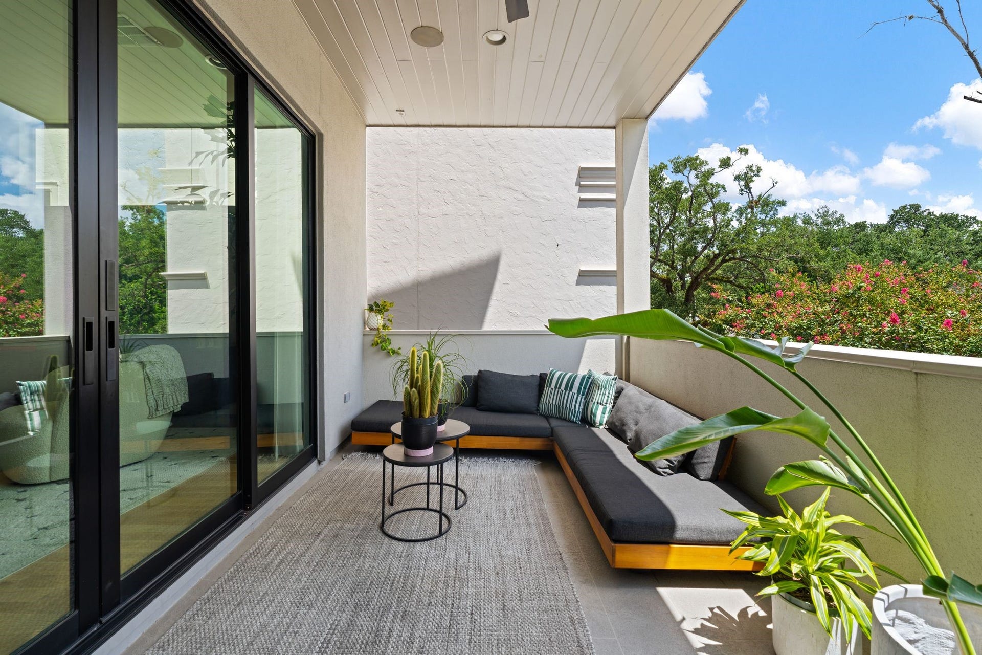 2622 Greenbriar Drive, Houston, TX 77098 Covered second-floor terrace overlooking the mature treetops along Greenbriar, featuring an outdoor fireplace, built-in speakers and ceiling fan for comfortable outdoor living and entertaining.