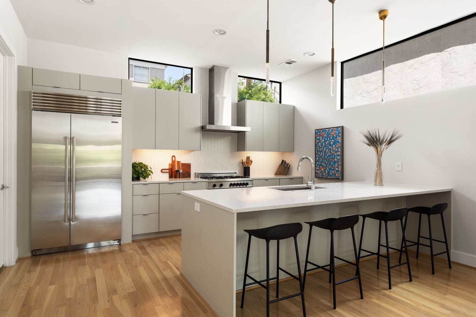 2622 Greenbriar Drive, Houston, TX 77098 Elevated kitchen featuring an upgraded built-in Sub-Zero refrigerator, custom cabinetry, hardwood floors, and a streamlined contemporary aesthetic.