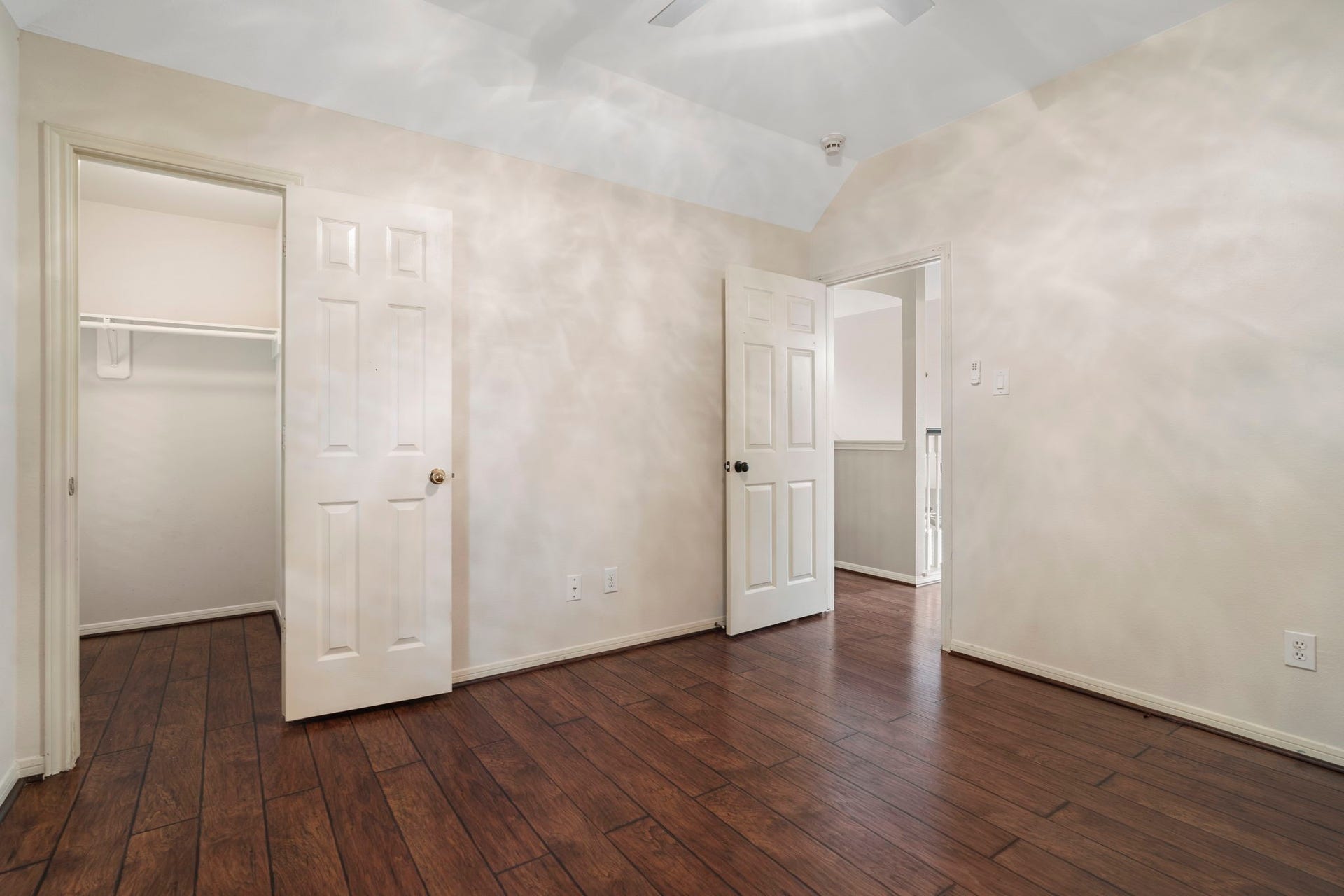 9730 Harrison Lane, Missouri City, TX 77459 Alternate angle of secondary bedroom displaying the deep walk-in closet space and rich wood-look LVP flooring.