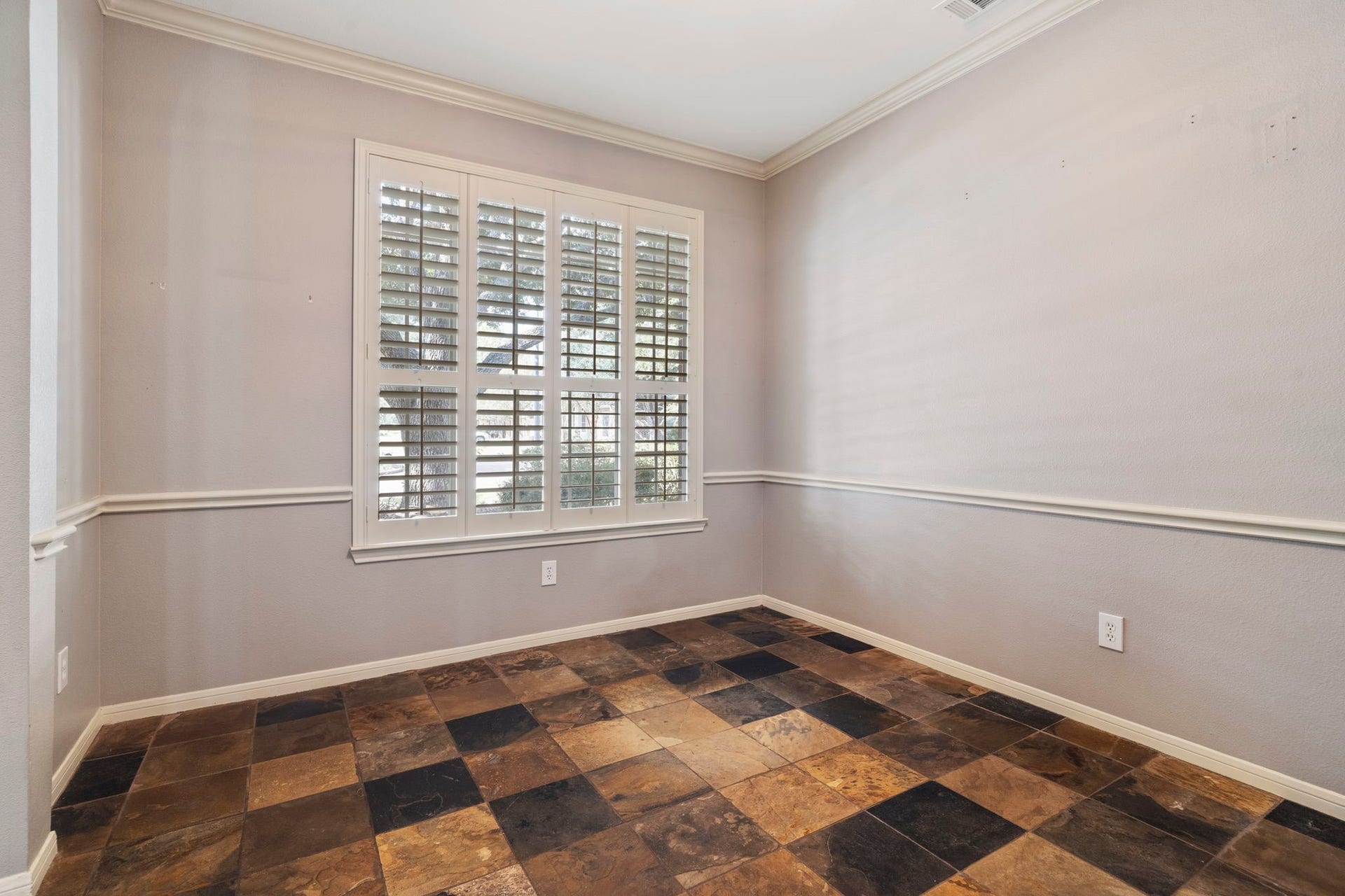 9730 Harrison Lane, Missouri City, TX 77459 Versatile main-floor study featuring low-maintenance natural slate tile flooring, classic wall chair rail molding, ceiling fan, and large front-facing windows with custom plantation shutters.
