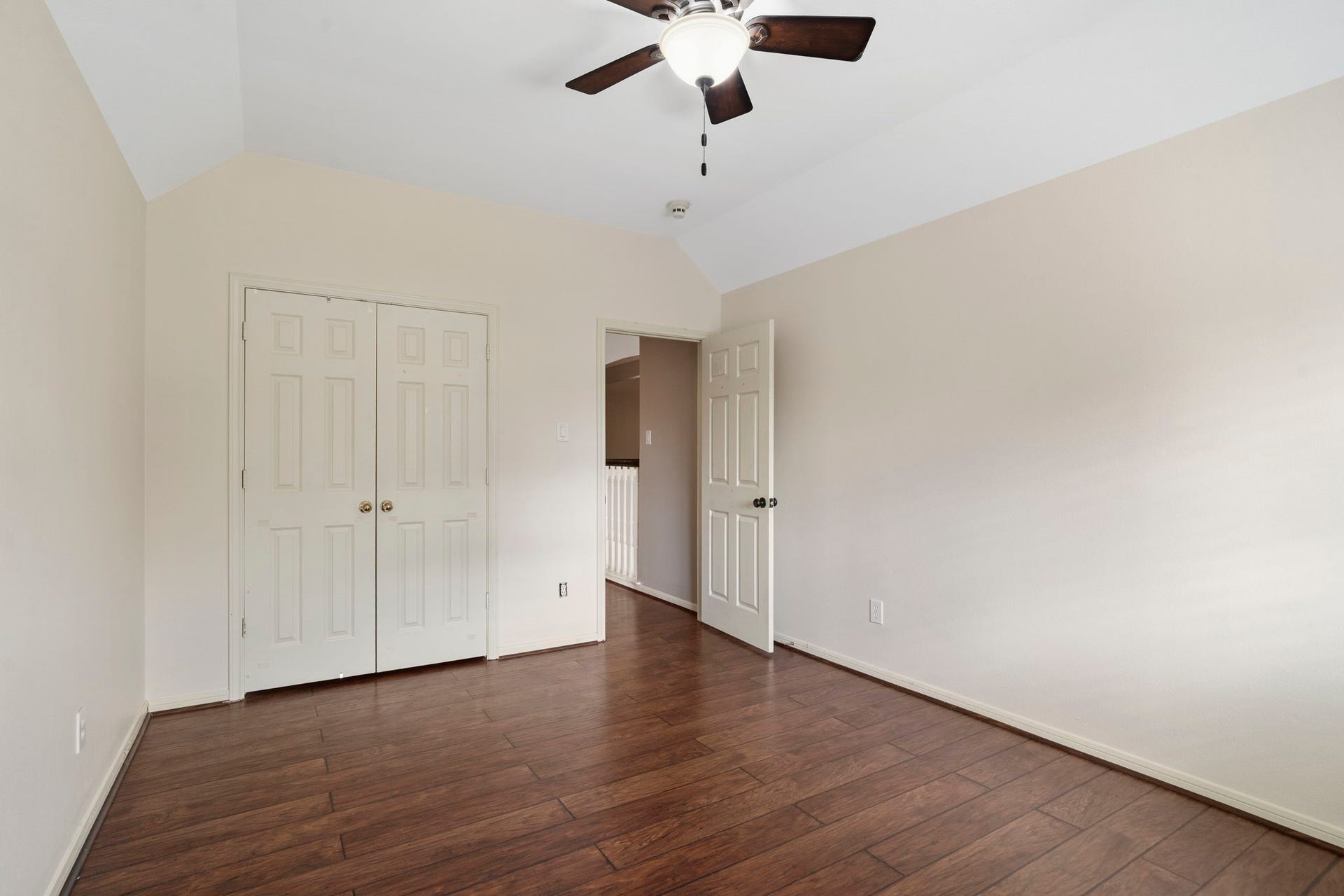 9730 Harrison Lane, Missouri City, TX 77459 Secondary bedroom showing the double-door closet storage, wood-look LVP flooring, and smooth transition into the upper-level hallway.