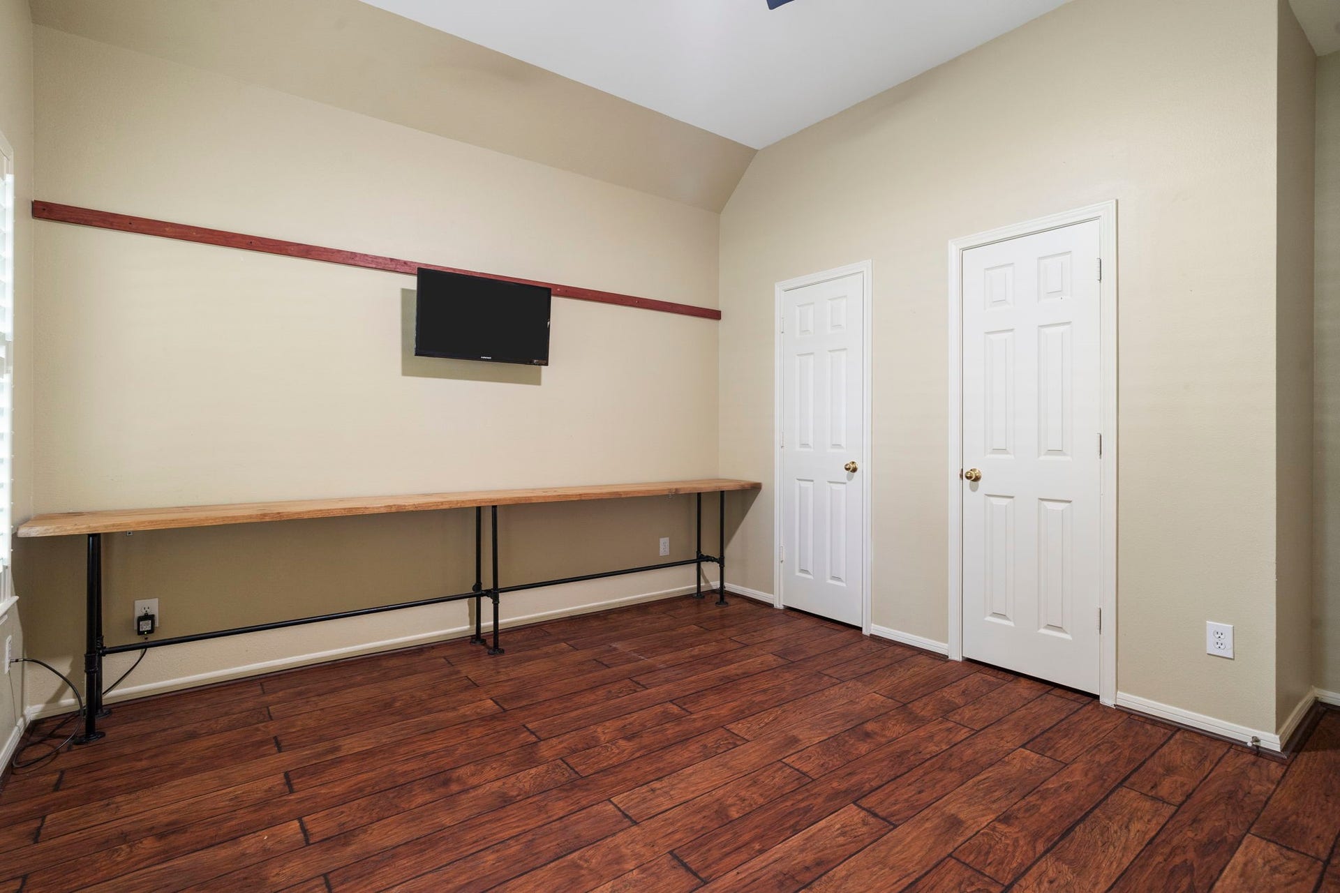 9730 Harrison Lane, Missouri City, TX 77459 Alternate angle of the main-floor home office illustrating the vast layout, built-in dual work surface, double-door closet space, and rich wood-look flooring.