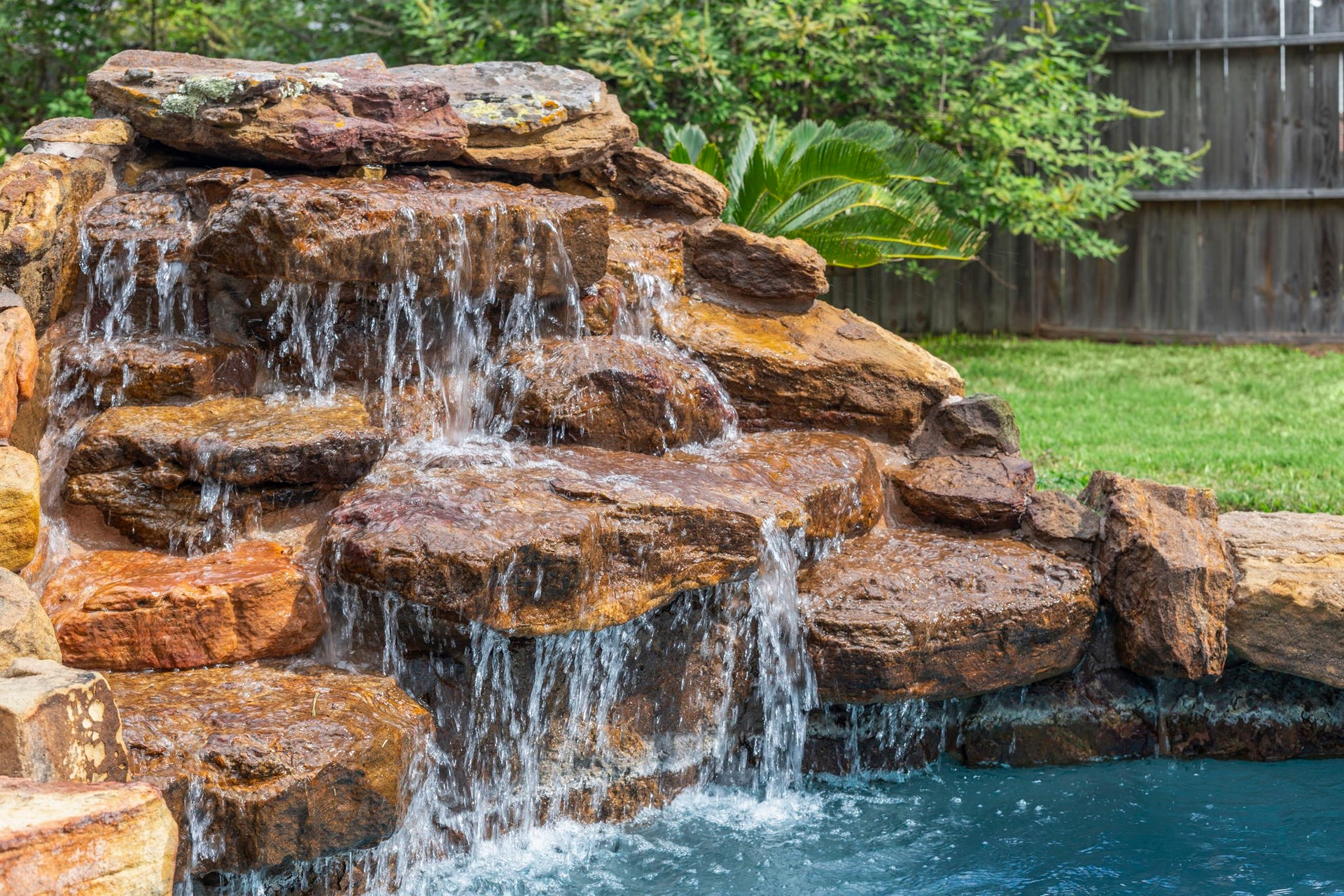 9730 Harrison Lane, Missouri City, TX 77459 Beautiful stone waterfall creates a relaxing, resort-style atmosphere in the backyard pool.