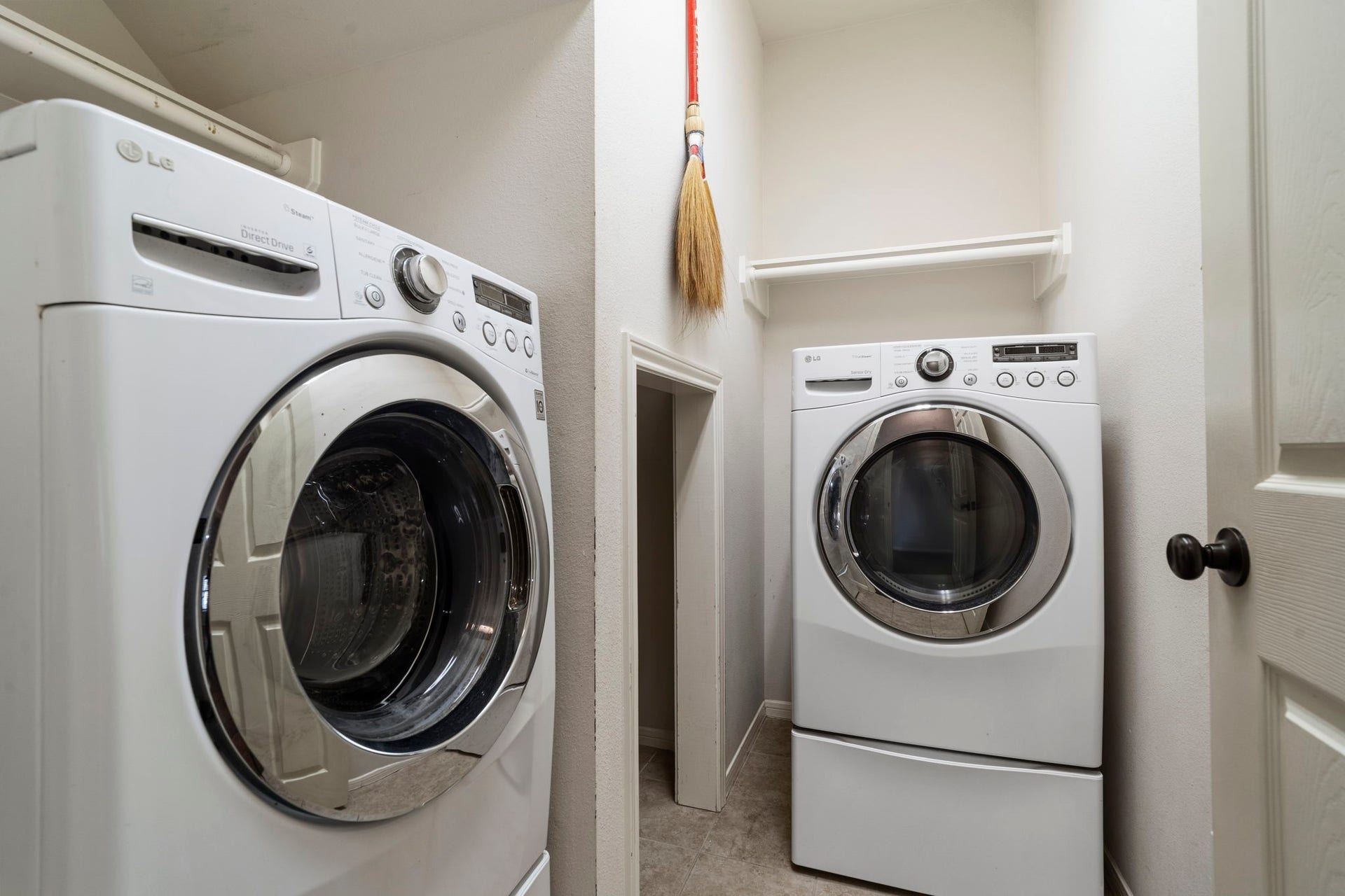 9730 Harrison Lane, Missouri City, TX 77459 Dedicated interior utility room equipped with full-sized front-loading washer and dryer, overhead storage shelving, and custom under-stair alcove storage.