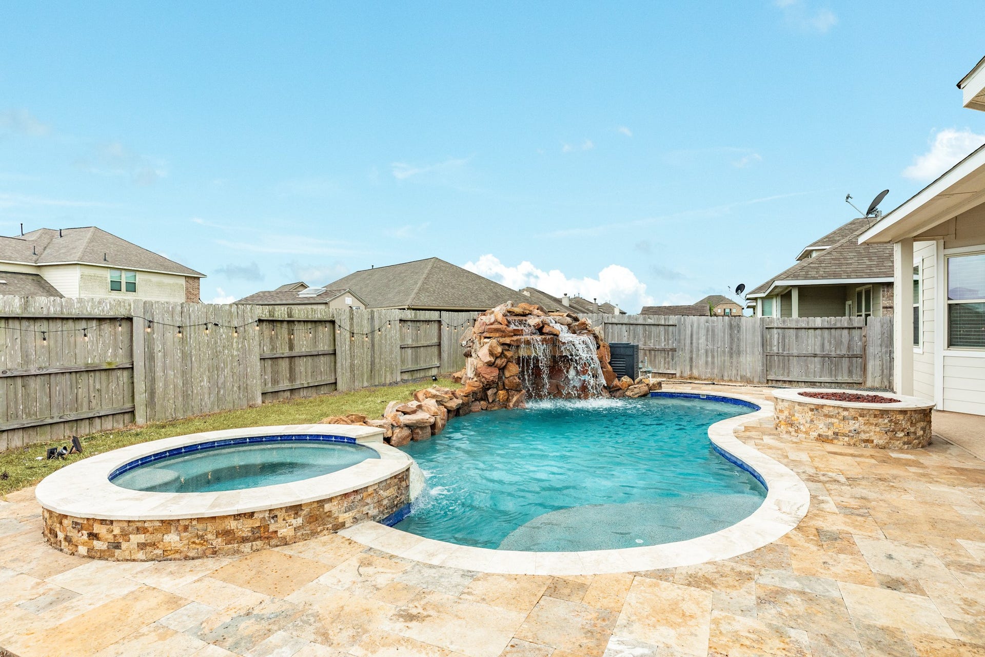 1702 Diamond Mountain Drive, Rosharon, TX 77583 Resort-style backyard featuring a sparkling pool, raised spa, stunning rock waterfall and fire pitperfect for outdoor entertaining.