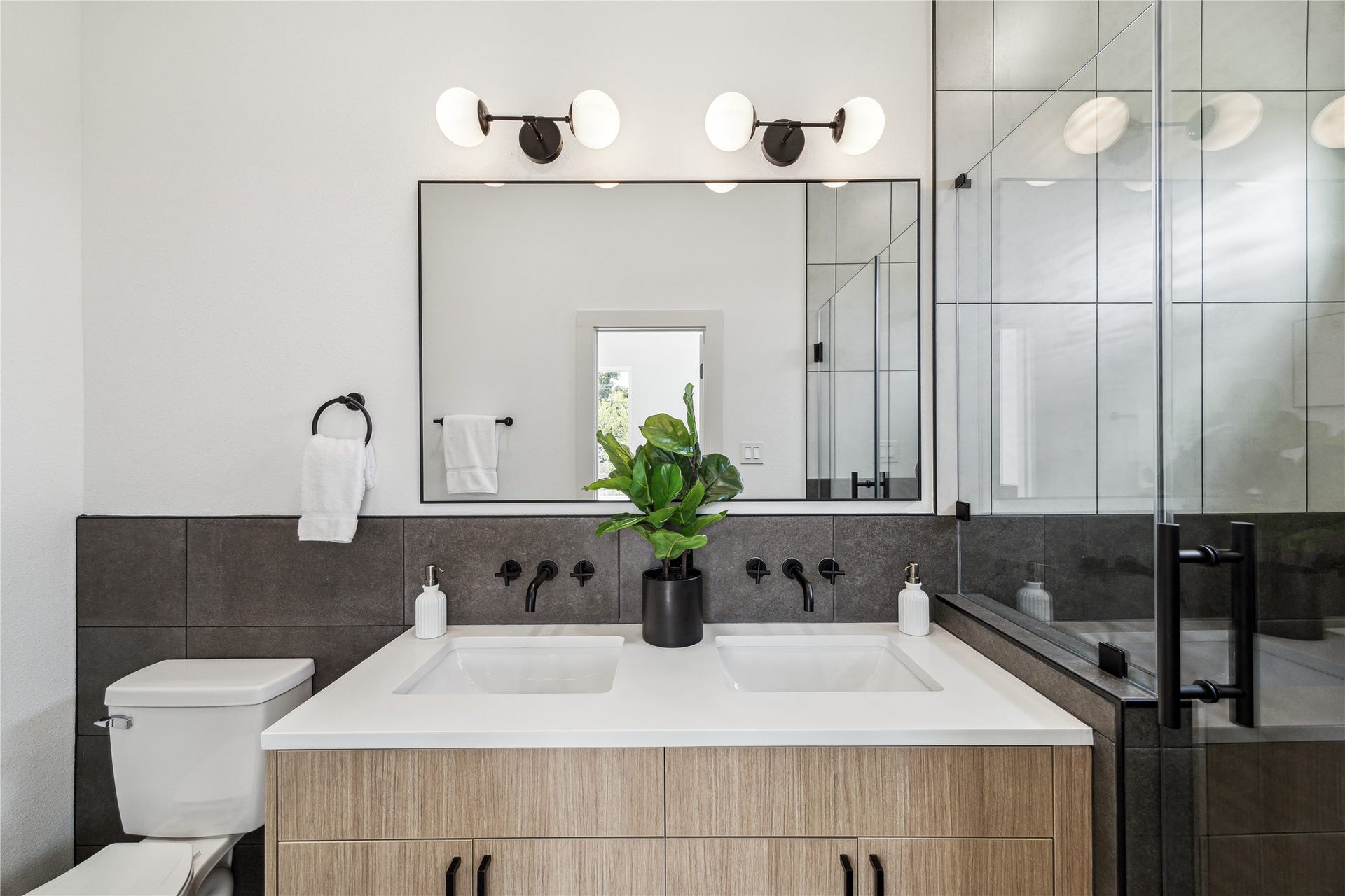 4415 Buck Street, #A/B, Houston, TX 77020 Purposefully designed primary bathroom featuring floor to ceiling tile, bringing a spa inspired feel and elevated detail to the home.
