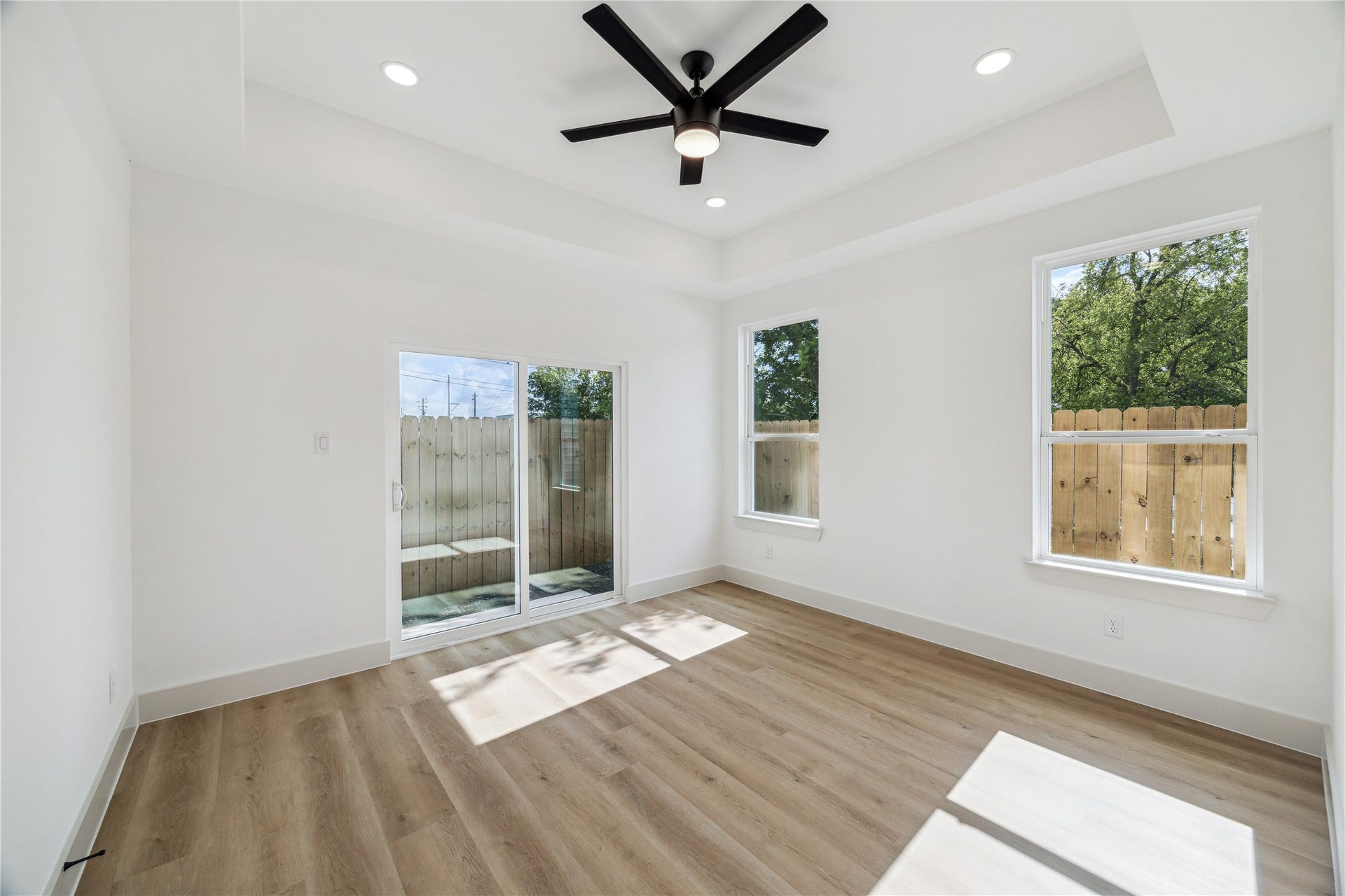4415 Buck Street, #A/B, Houston, TX 77020 Primary suite featuring sliding glass door for convenient backyard access, creating a seamless connection between indoor and outdoor living.