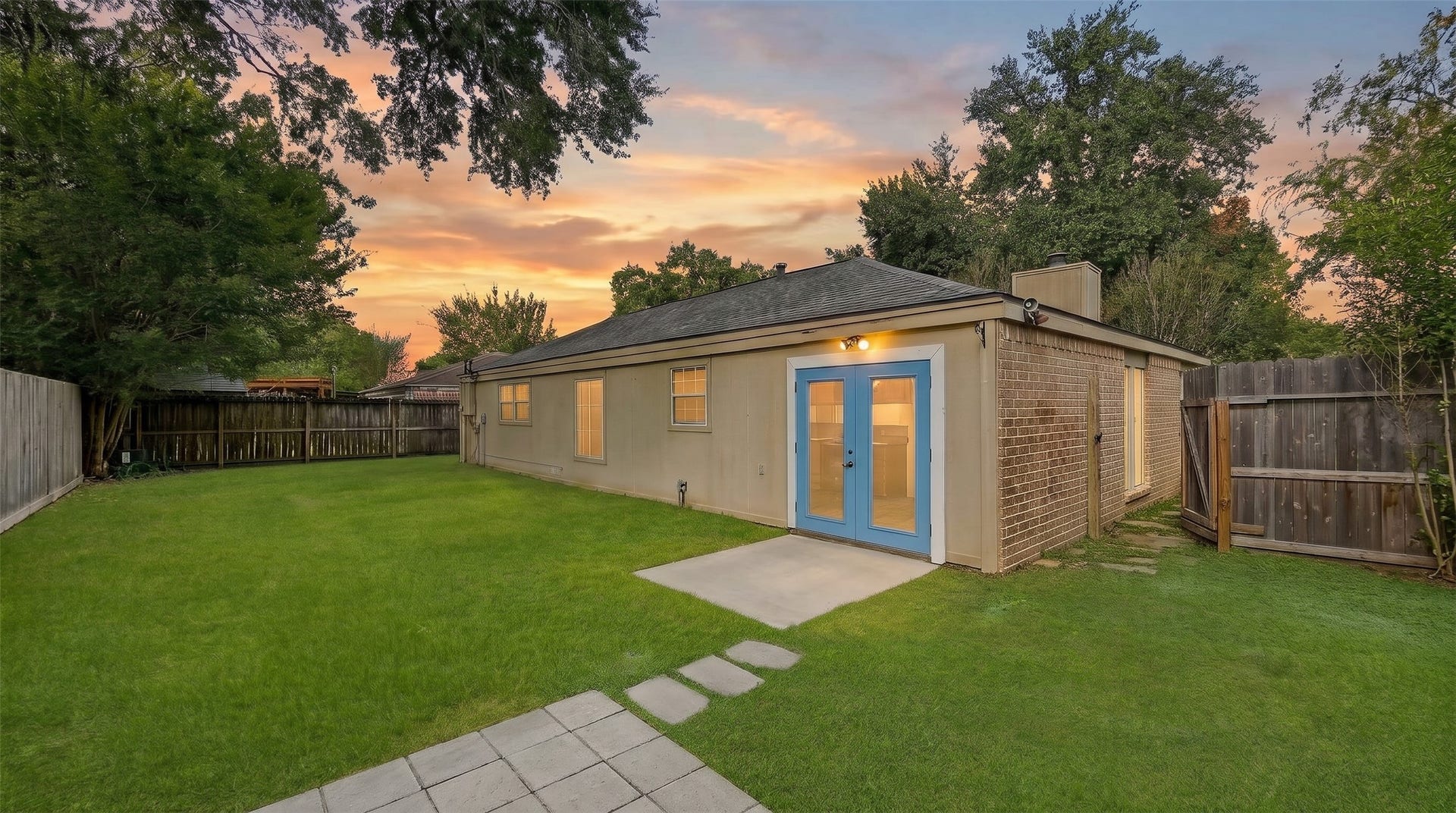 22711 Provincial Boulevard, Katy, TX 77450 Embrace relaxed outdoor living in this serene, fully fenced backyard haven, surrounded by leafy canopy trees and sprawling green lawn. A charming stone path connects paved open-air patios, offering ideal spots for weekend grilling or twilight gatherings.
