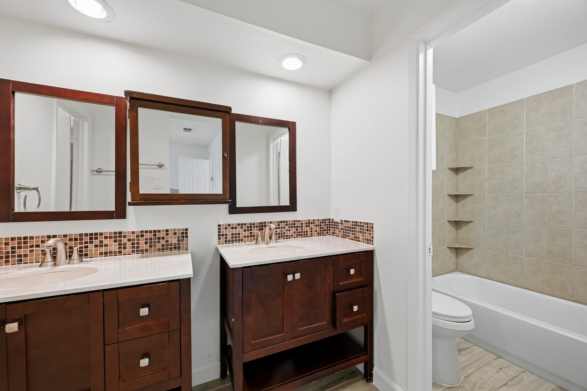 22711 Provincial Boulevard, Katy, TX 77450 Brightened by overhead recessed lighting, the open layout leads into an adjoining wet area featuring a tub-shower combination with floor-to-ceiling tiling and built-in corner shelves.