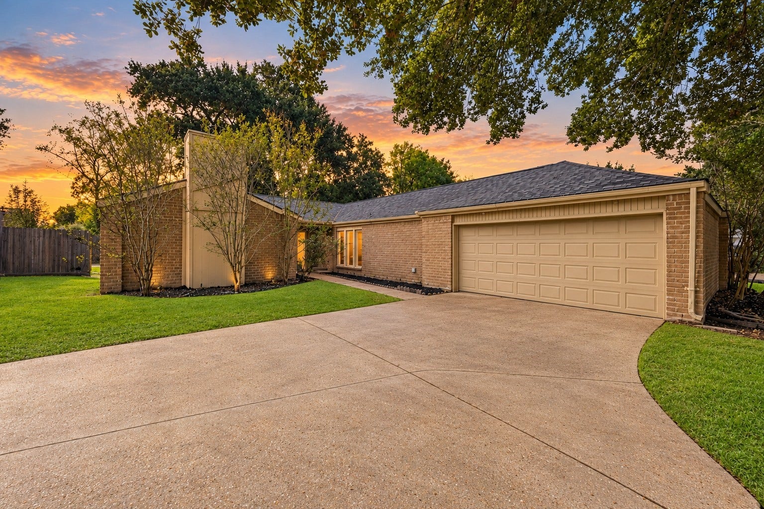 22711 Provincial Boulevard, Katy, TX 77450 The home's layout incorporates classic exterior angles and an integrated chimney accent, with soft foundation lighting that beautifully illuminates the masonry as evening falls.