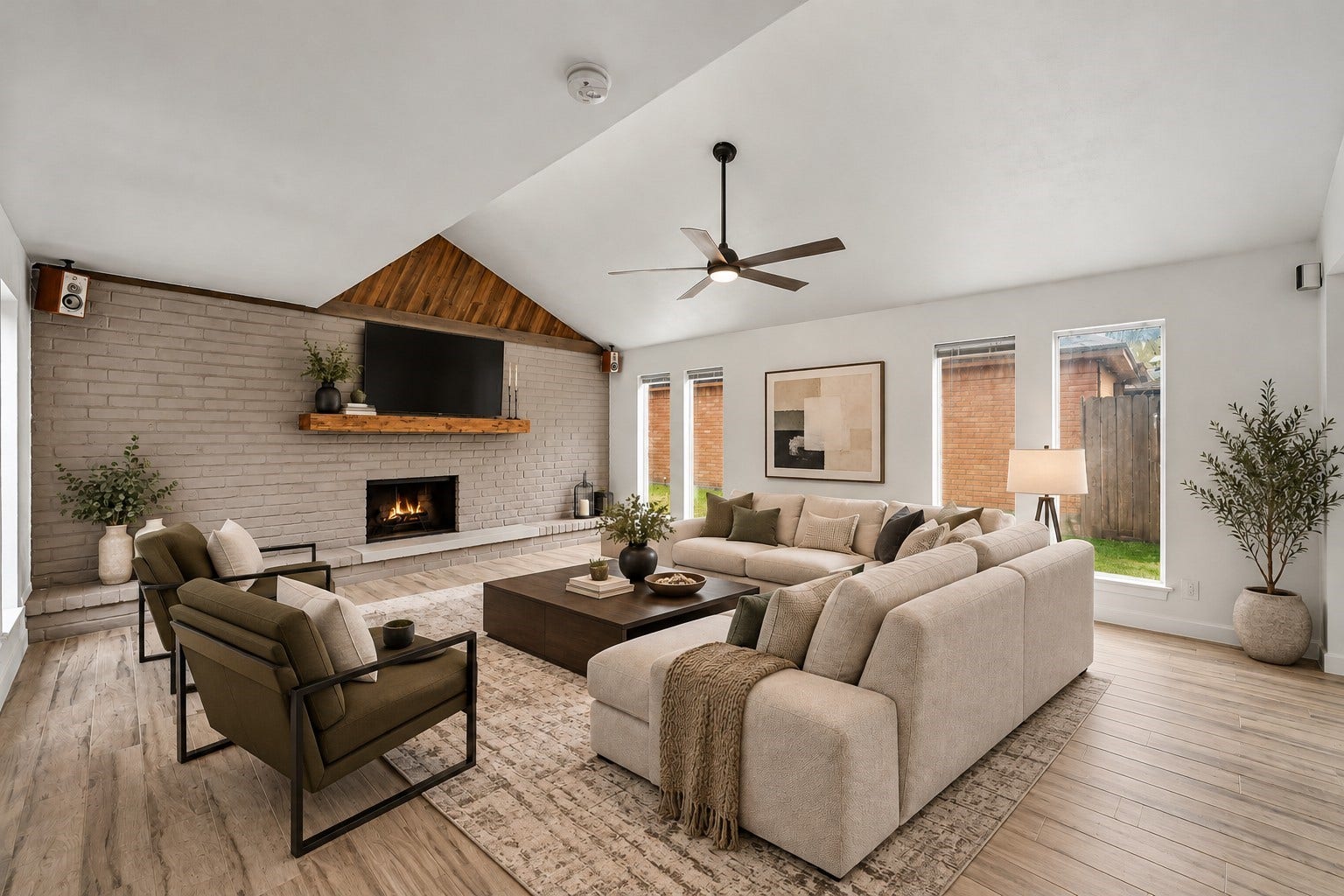 22711 Provincial Boulevard, Katy, TX 77450 Virtually Staged: Soaring vaulted ceilings and an expansive layout make this living room the ultimate welcoming gathering space. A full-height brick accent wall anchors the room, complete with an extended hearth, a cozy fireplace.