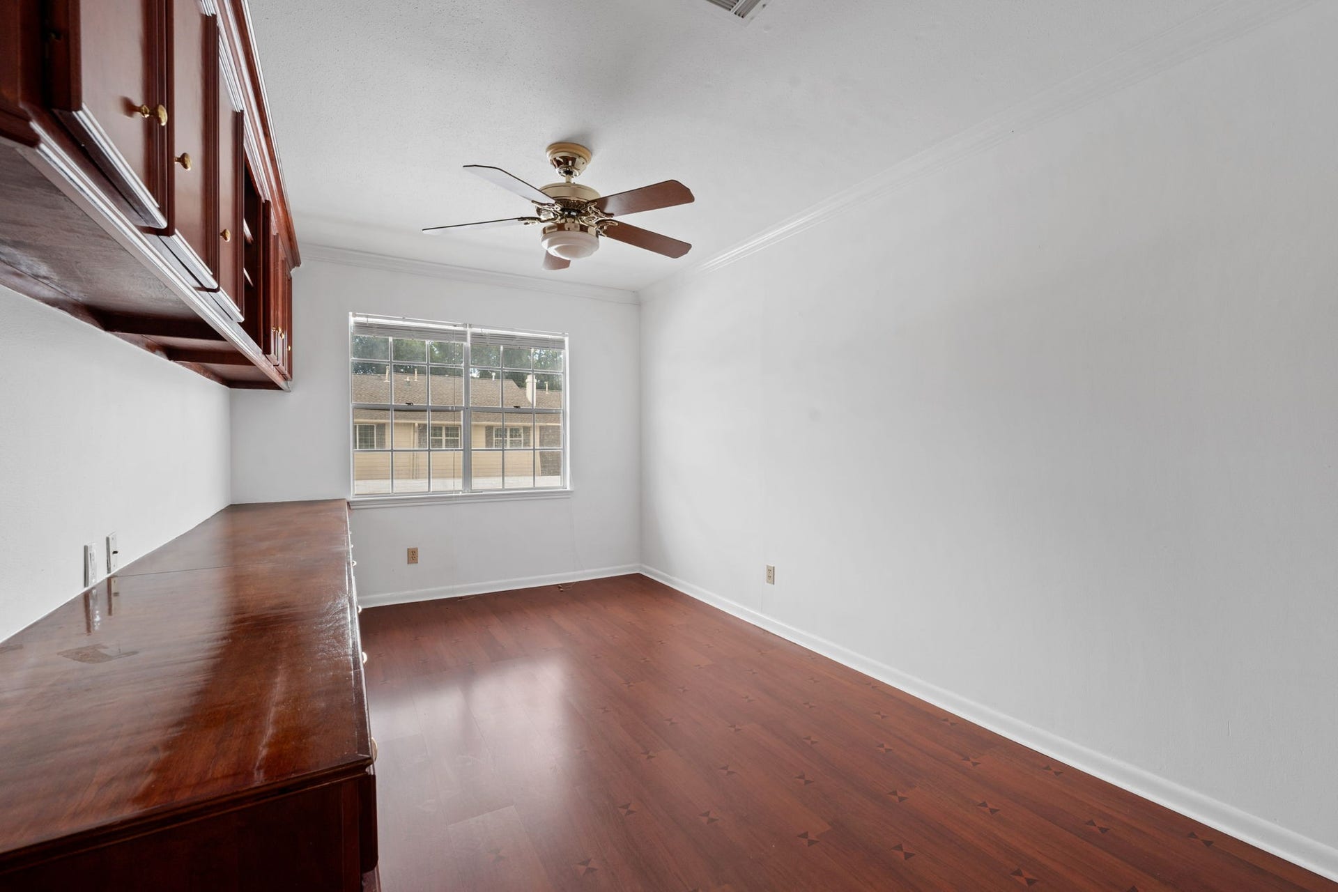 5819 Valley Forge Drive, #91, Houston, TX 77057 Bright room with elegant wood flooring, built-in cabinetry, and a ceiling fan, offering a cozy and functional space.