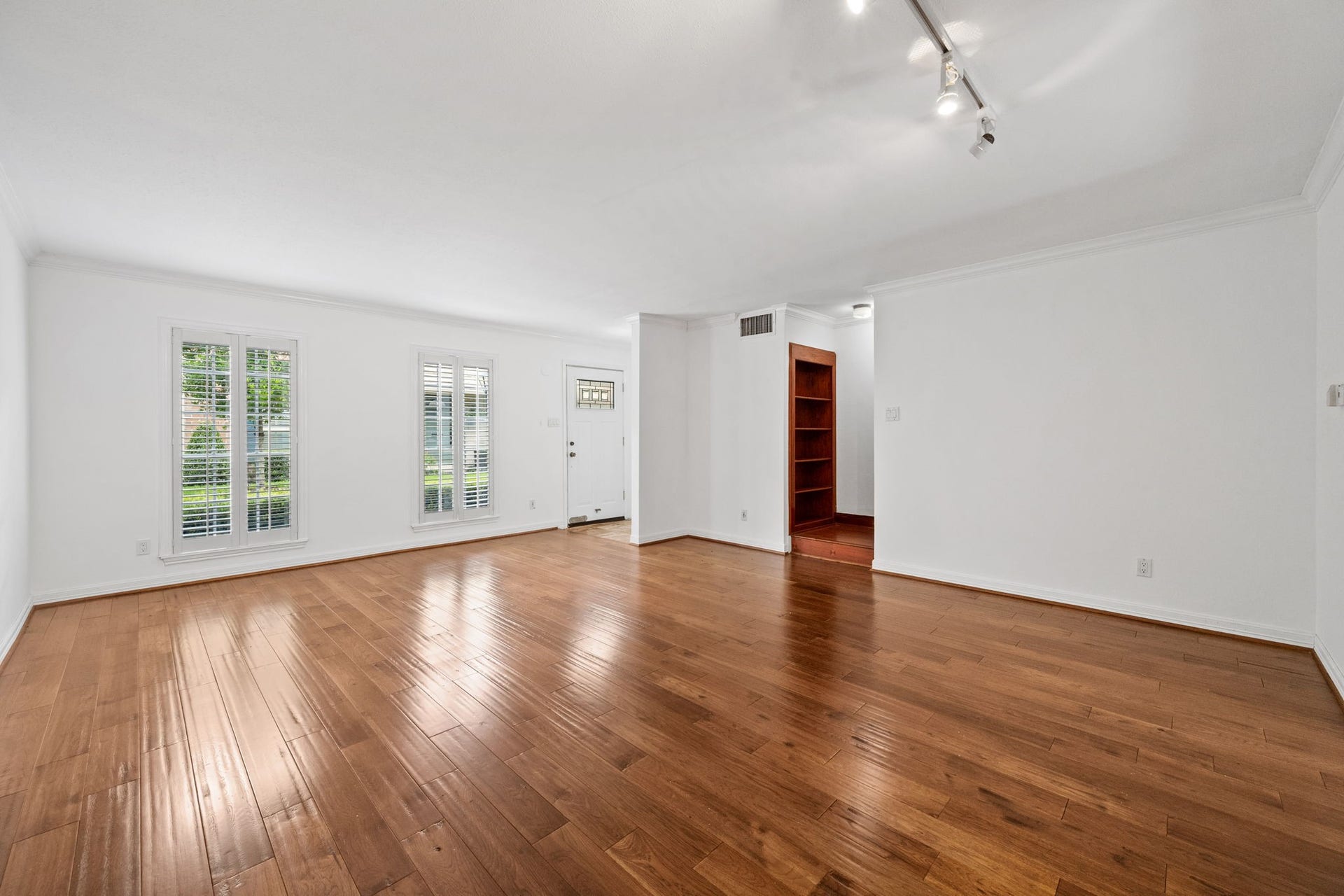 5819 Valley Forge Drive, #91, Houston, TX 77057 Spacious living area with gleaming hardwood floors, abundant natural light from large windows, and modern track lighting.