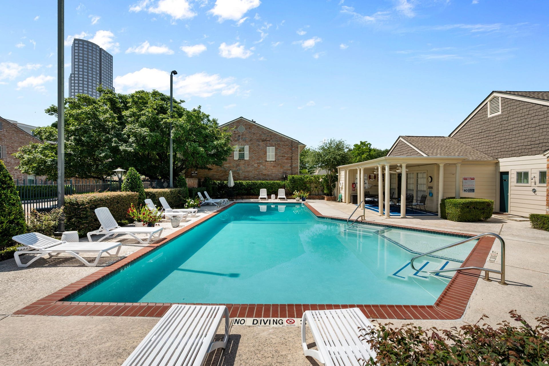 5819 Valley Forge Drive, #91, Houston, TX 77057 Relax by the sparkling outdoor pool, surrounded by comfortable lounge chairs and lush greenery, perfect for sunny afternoons.
