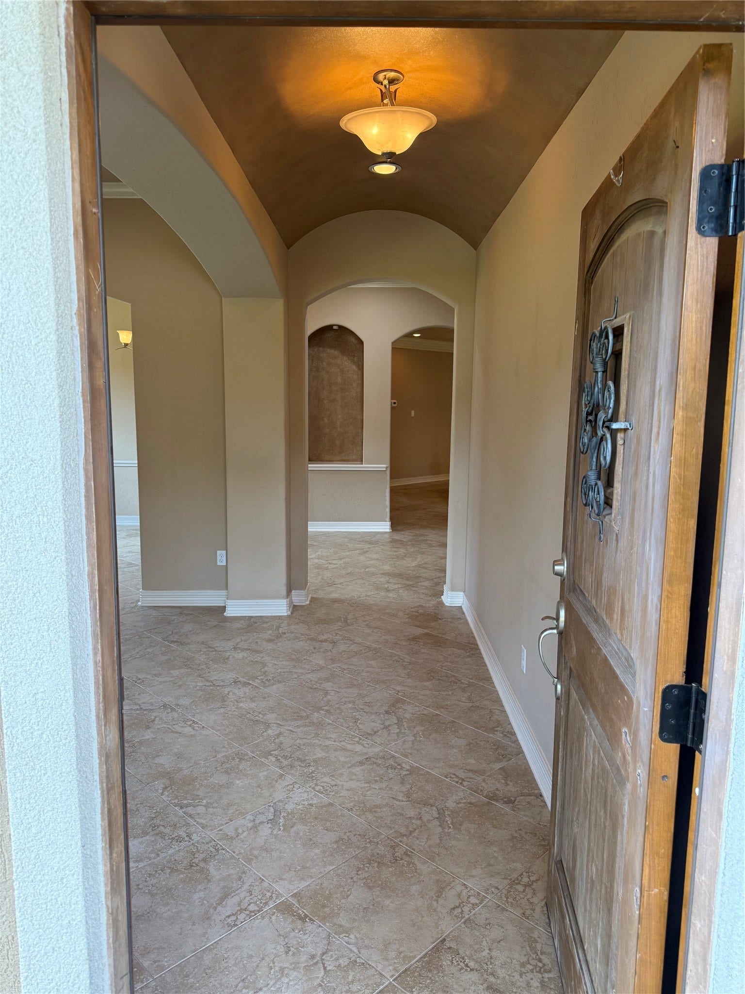 19841 S Plantation Estates Drive, Porter, TX 77365 Step into a welcoming foyer with elegant archways, warm lighting, and beautiful tile flooring, offering a glimpse into a spacious and inviting home.