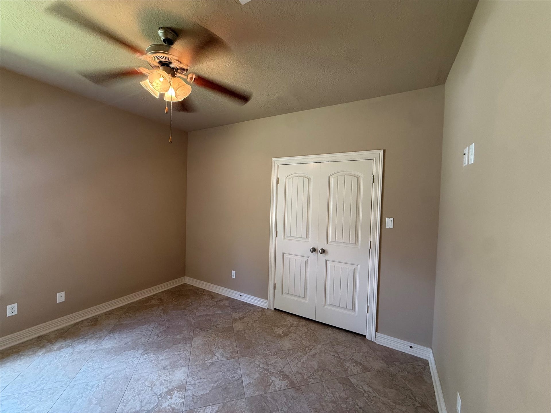 19841 S Plantation Estates Drive, Porter, TX 77365 Spacious room with neutral walls, tiled flooring, and a ceiling fan, featuring a double-door closet.