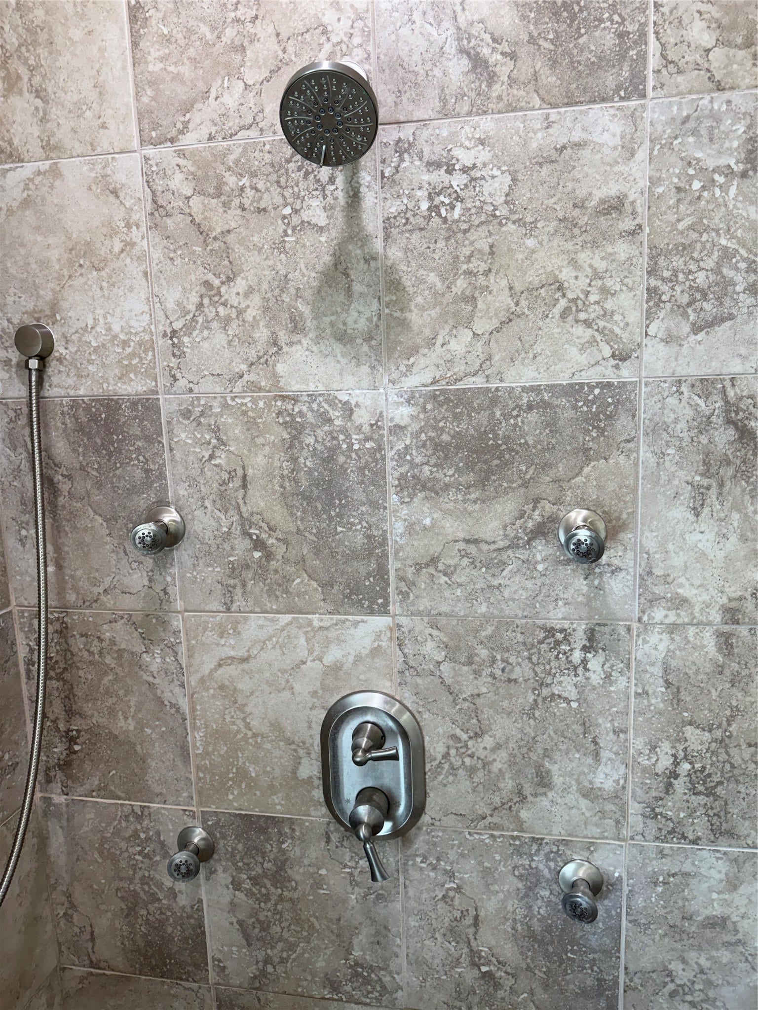 19841 S Plantation Estates Drive, Porter, TX 77365 Luxurious shower featuring elegant stone tile, multiple body jets, and a sleek rainfall showerhead for a spa-like experience.