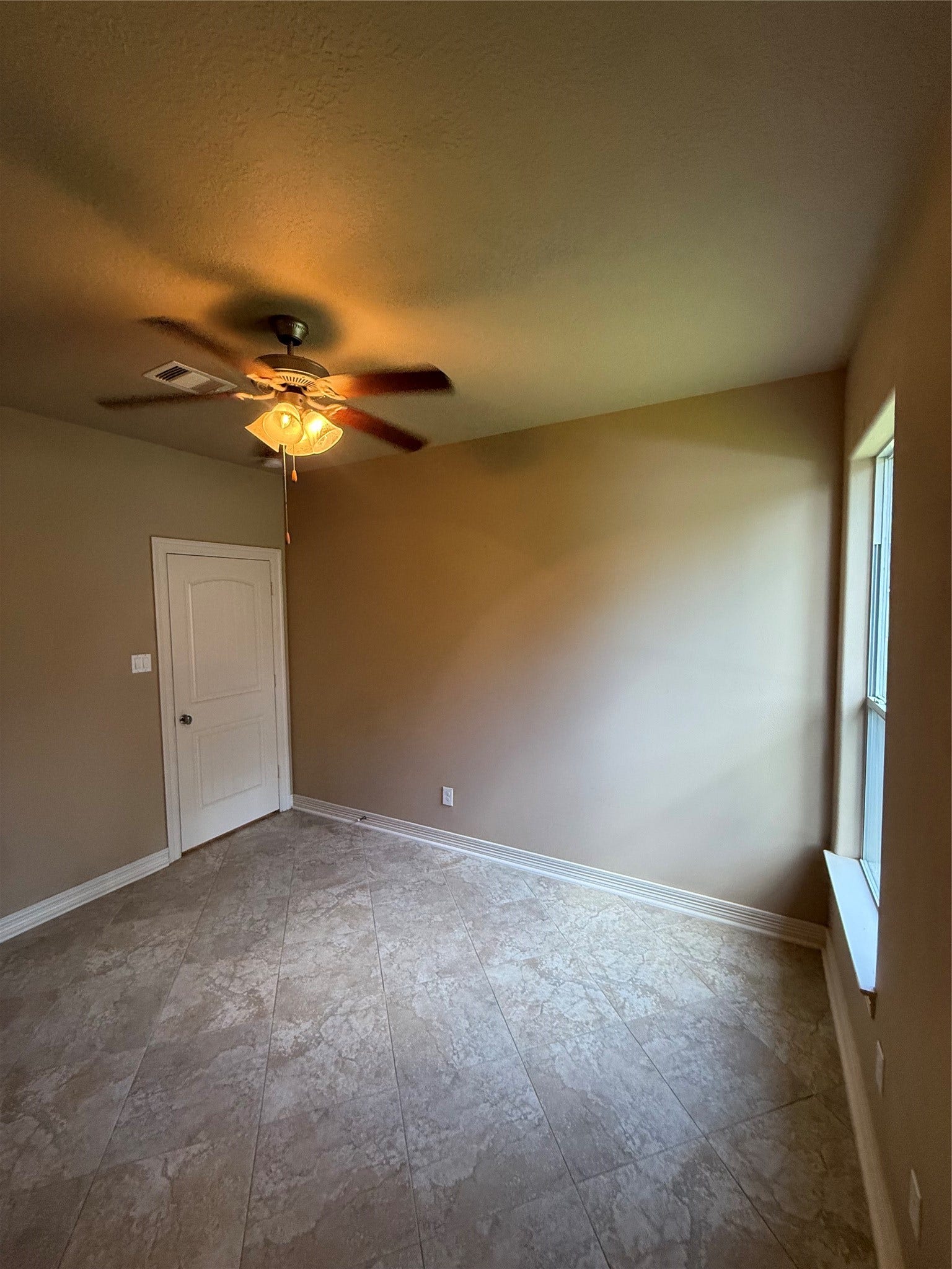 19841 S Plantation Estates Drive, Porter, TX 77365 Bright room with neutral walls, tiled flooring, and a ceiling fan, perfect for a cozy retreat or office space.