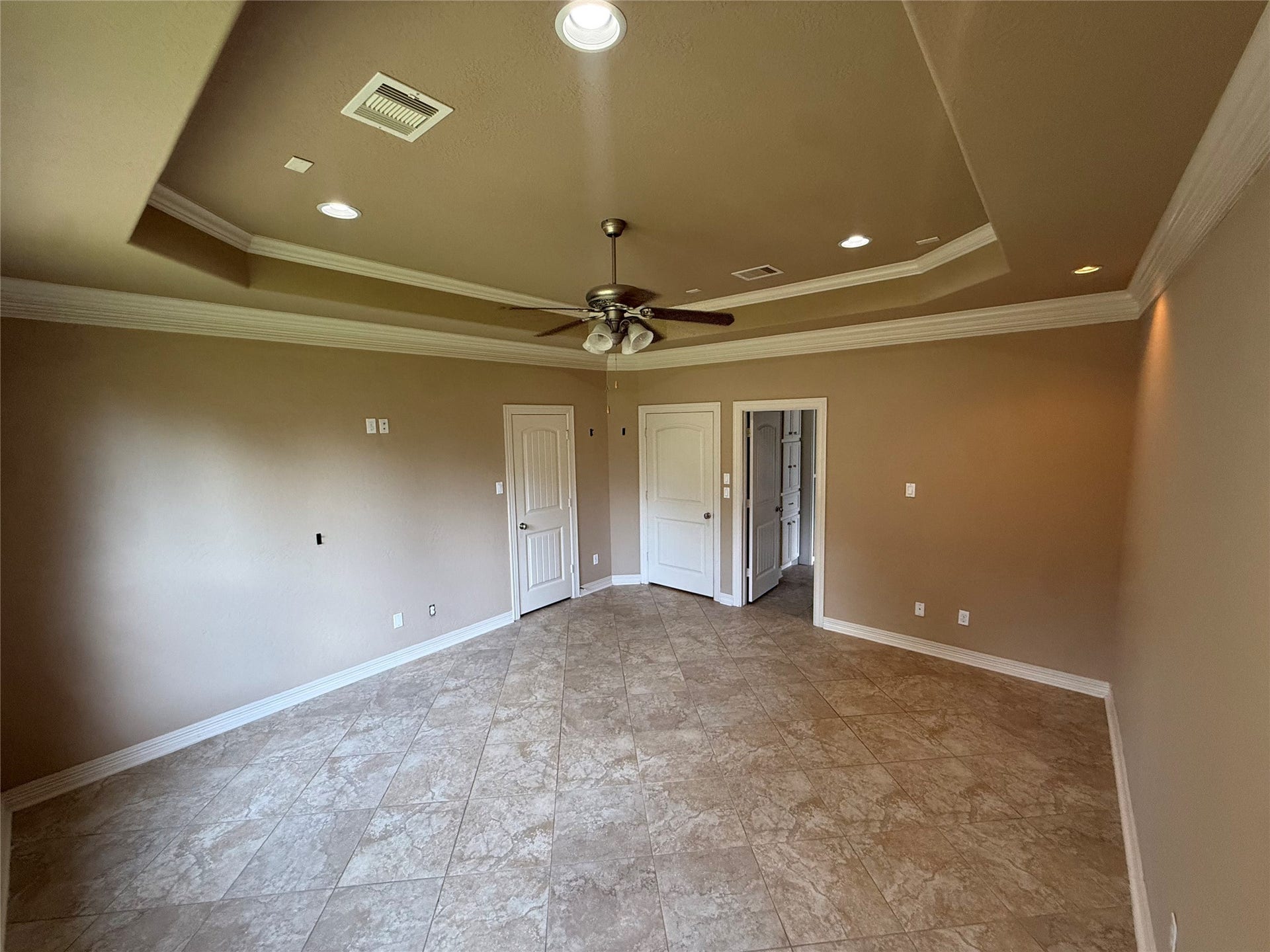 19841 S Plantation Estates Drive, Porter, TX 77365 Spacious Primary bedroom with elegant tray ceiling, & recessed lighting. Large windows offer abundant natural light and views of the backyard.