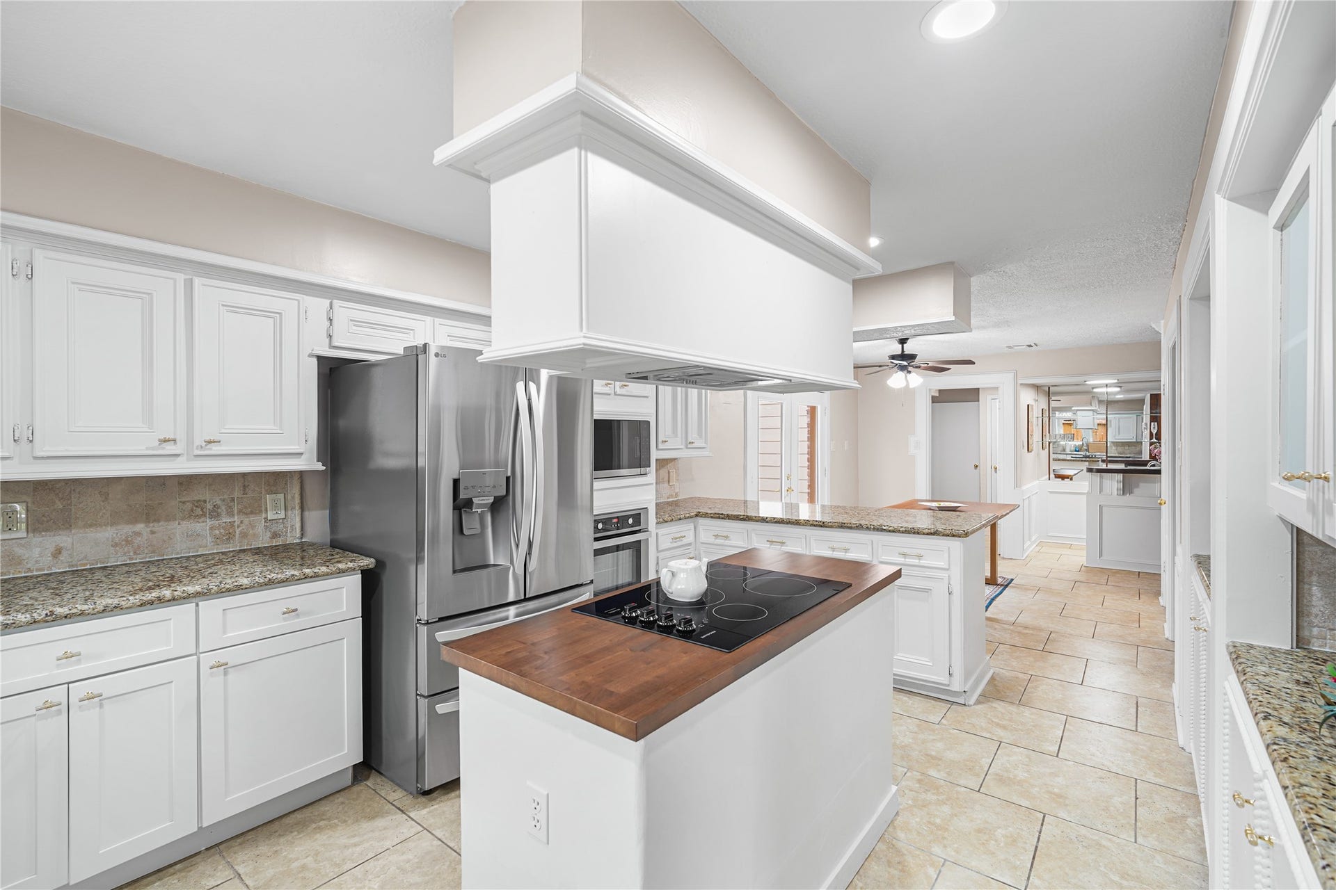 A central island with a cooktop, all set against elegant tile flooring.