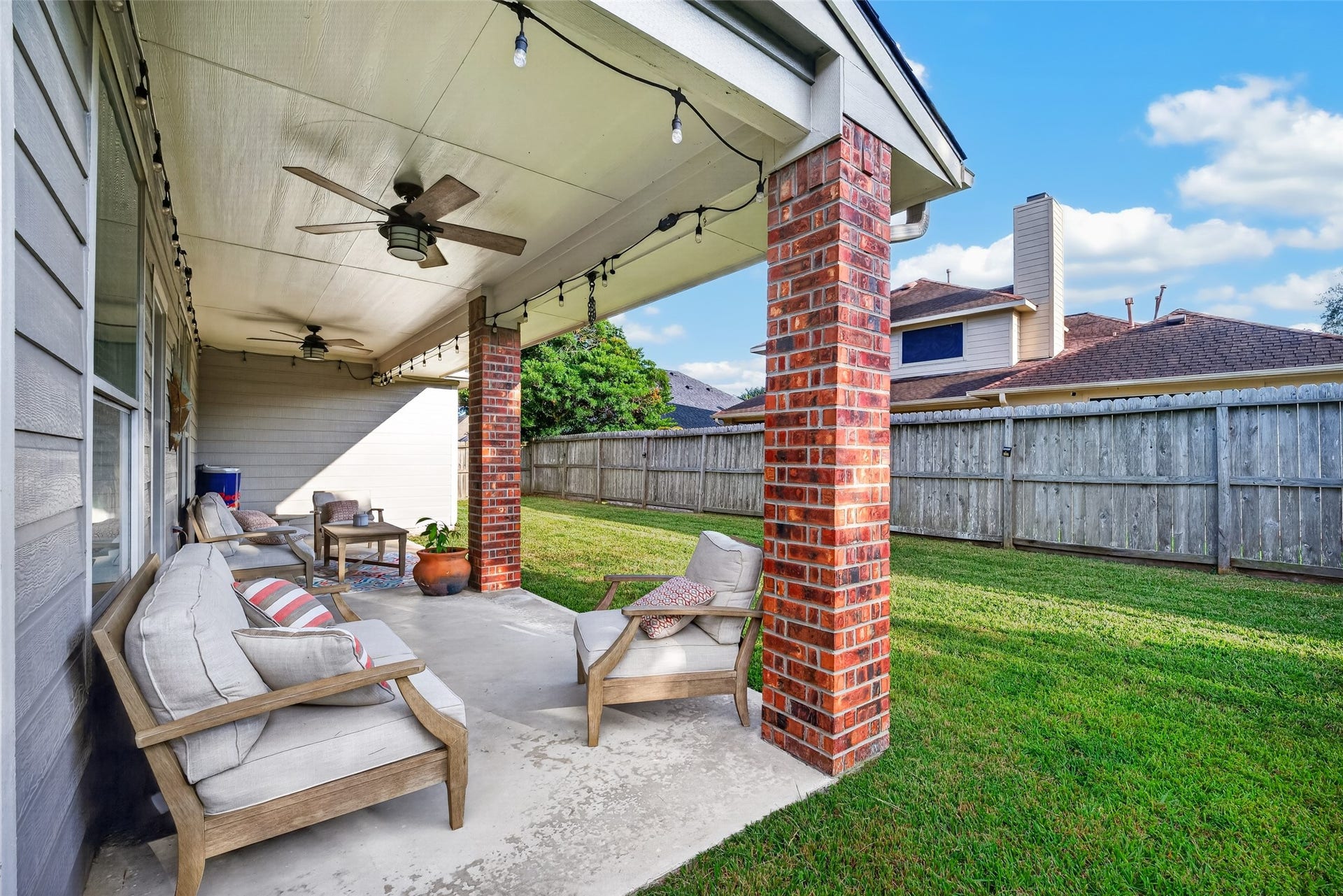 113 Erin Court, La Porte, TX 77571 Fenced backyard with patio seating and green lawn.