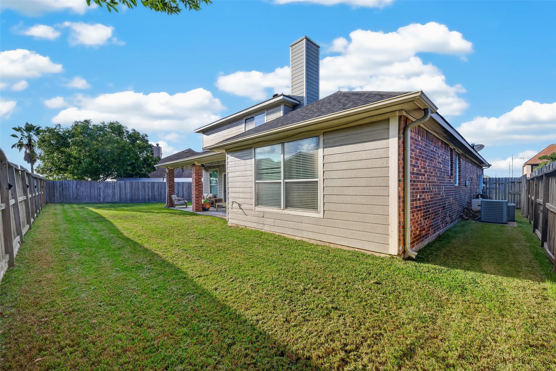 113 Erin Court, La Porte, TX 77571 Rear view of the two-story brick home and its lawn.