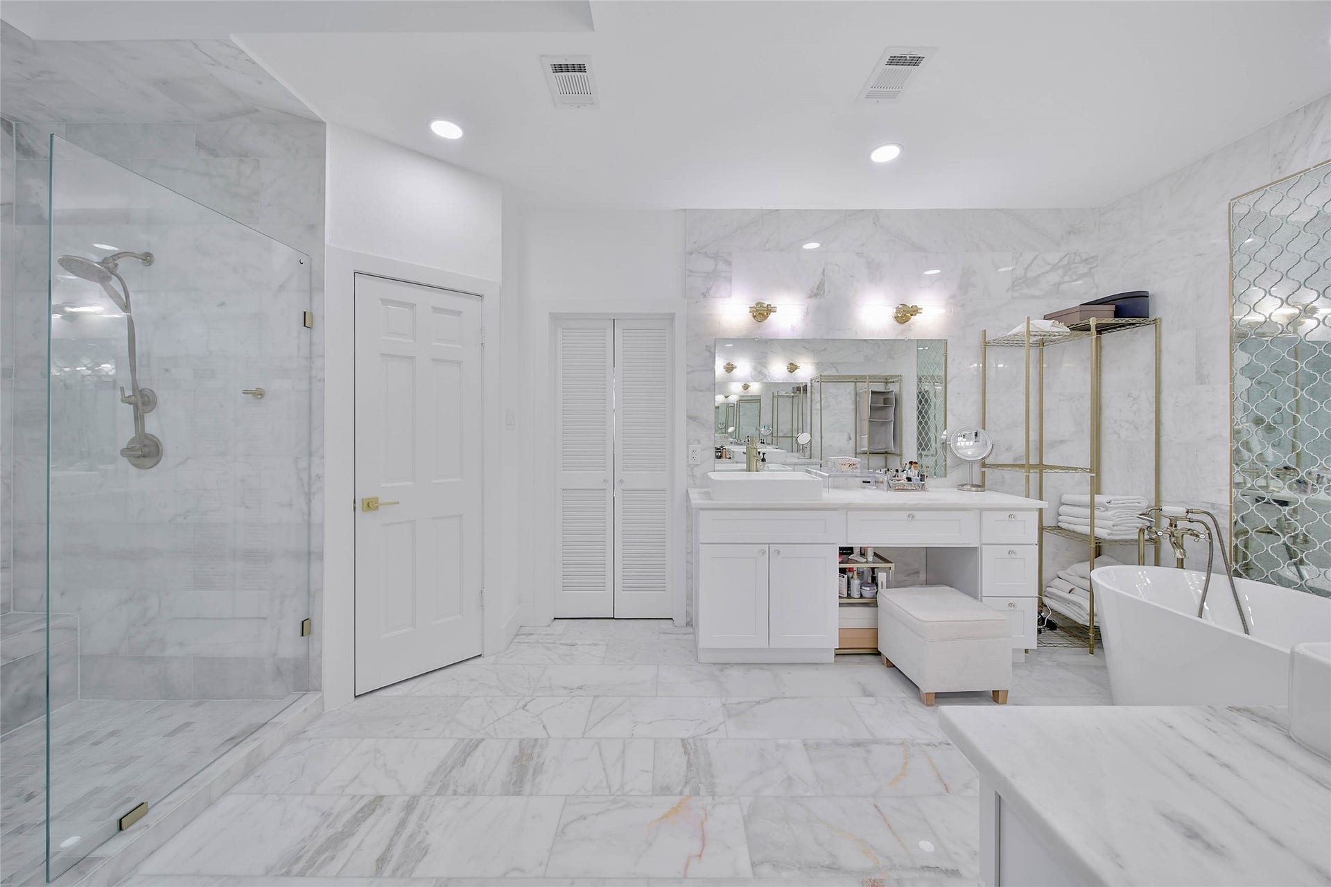 11 W Kitty Hawk ST, Richmond, TX 77406 Luxurious primary bath offers an expansive layout with extensive custom cabinetry and beautifully finished surfaces, 360 marble floors, ceiling shower and walls, her and his vanity, double doors.