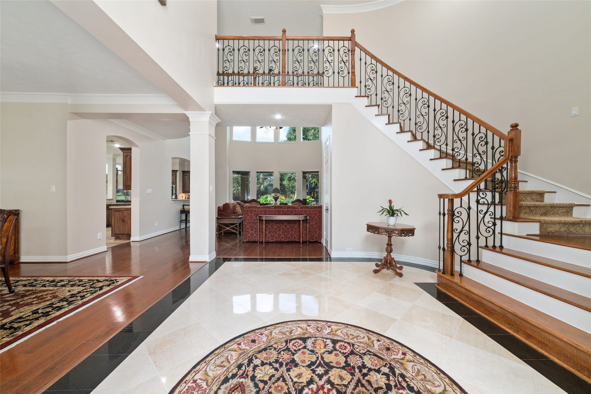 Enter the home through an elegant entryway with a grand staircase leading into a living space with large windows to overlook the backyard.