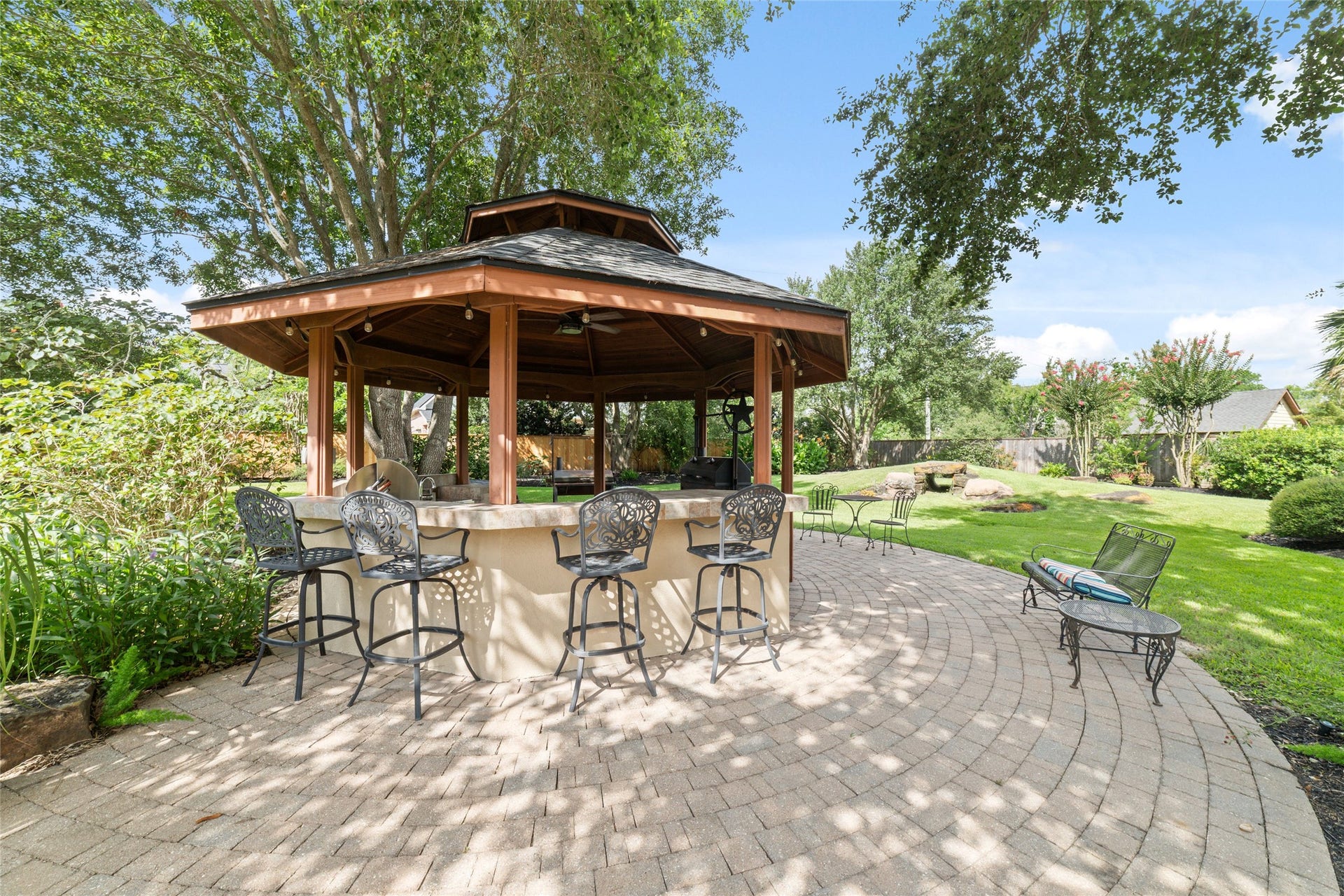 Spacious covered gazebo with bar seating offers a peaceful outdoor retreat.
