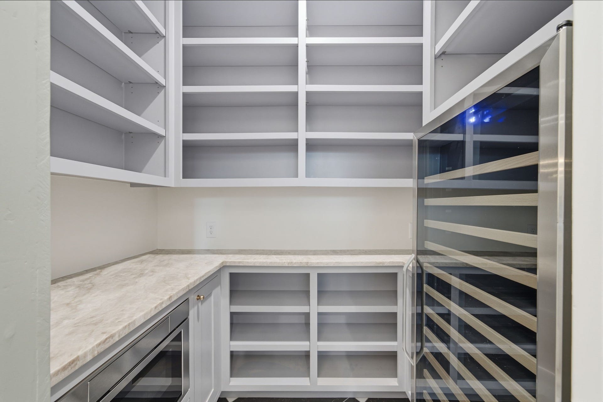 404 Avondale Street, Houston, TX 77006 Spacious walk-in pantry with ample shelving and a modern wine cooler, perfect for organized storage and entertaining essentials.