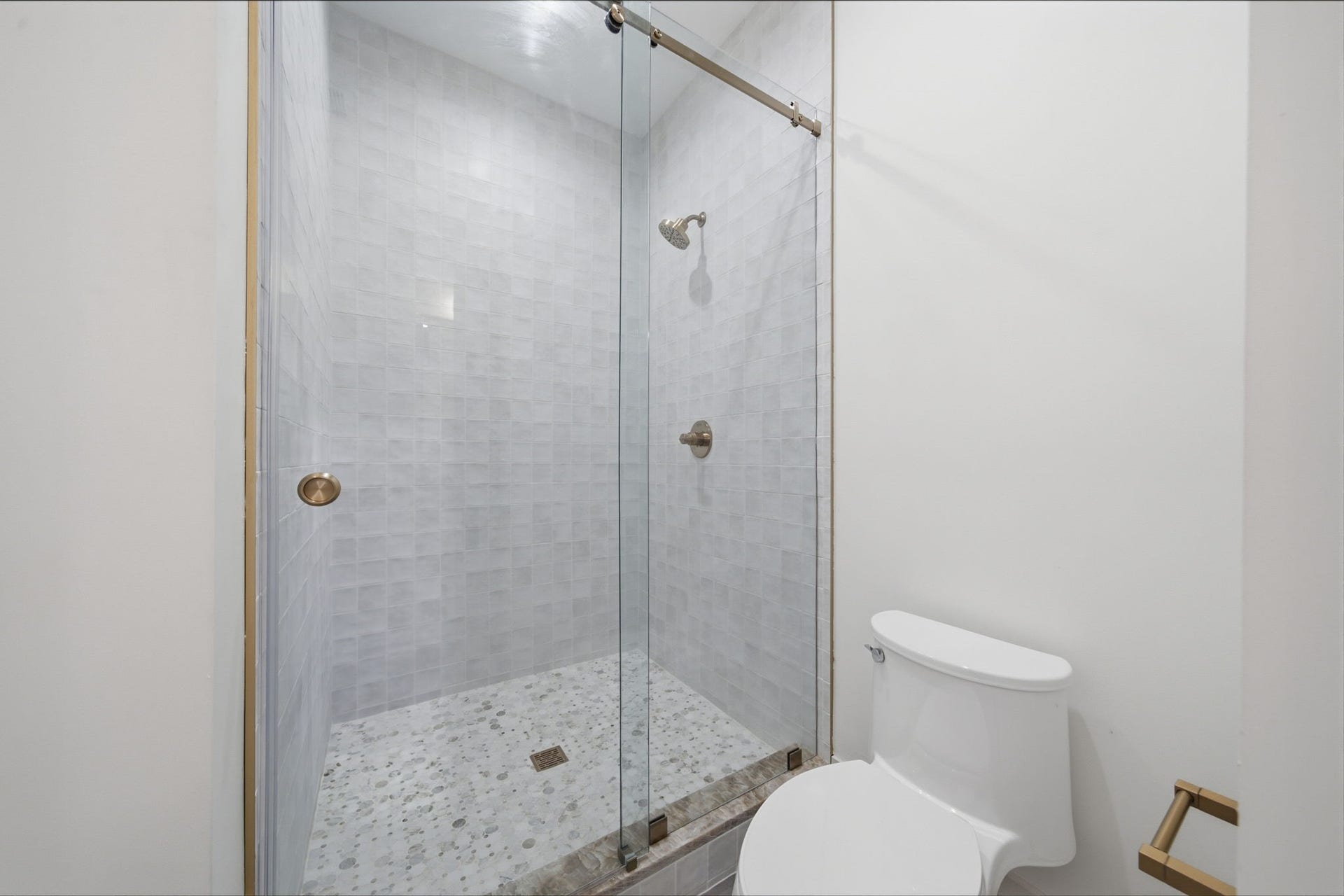404 Avondale Street, Houston, TX 77006 Featuring a modern glass-enclosed shower with sleek tilework and a convenient adjacent toilet.