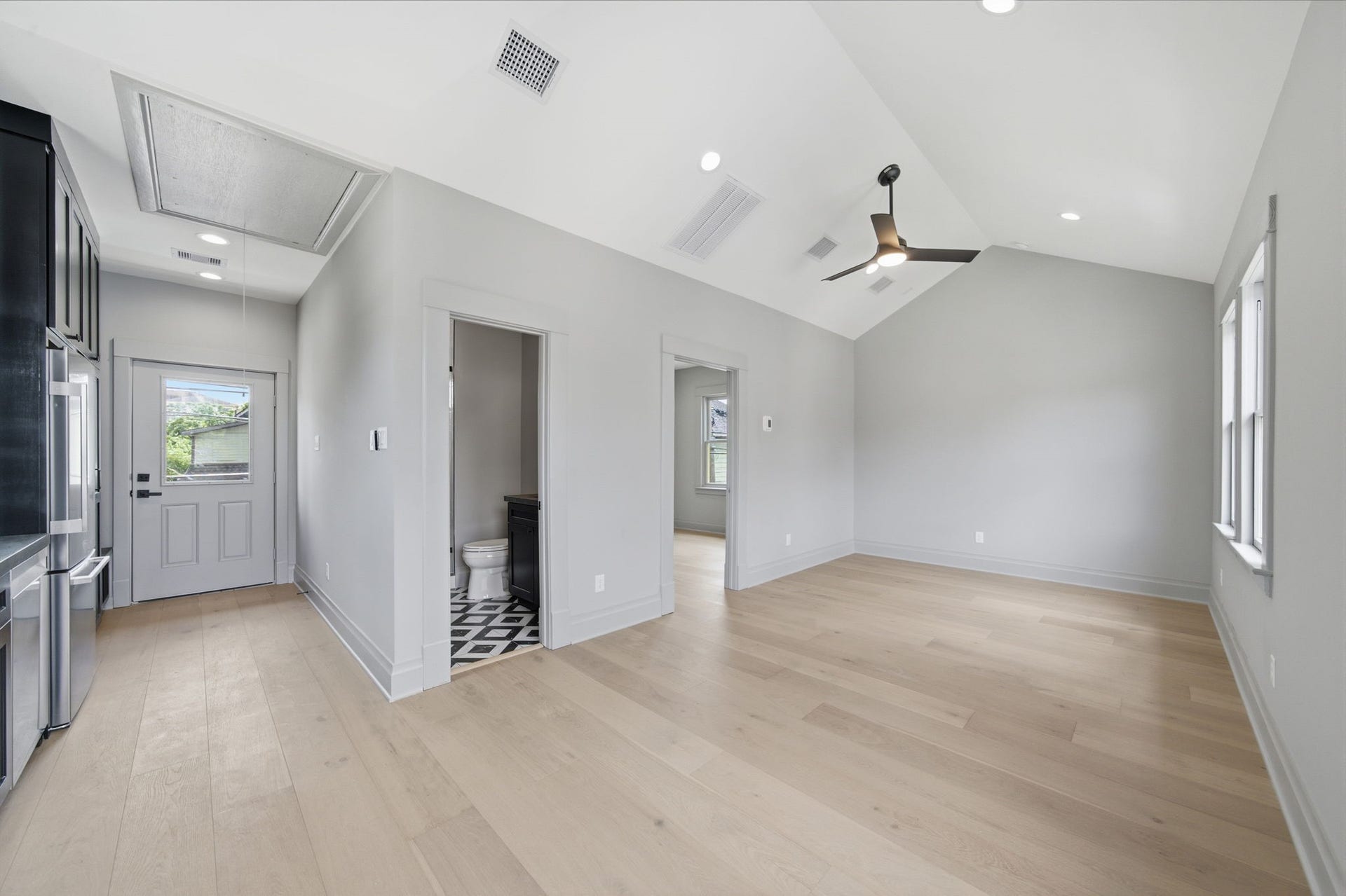 404 Avondale Street, Houston, TX 77006 Bright and airy living space with vaulted ceilings, light wood flooring, and modern fixtures, seamlessly connecting to a stylish kitchen and a chic bathroom.