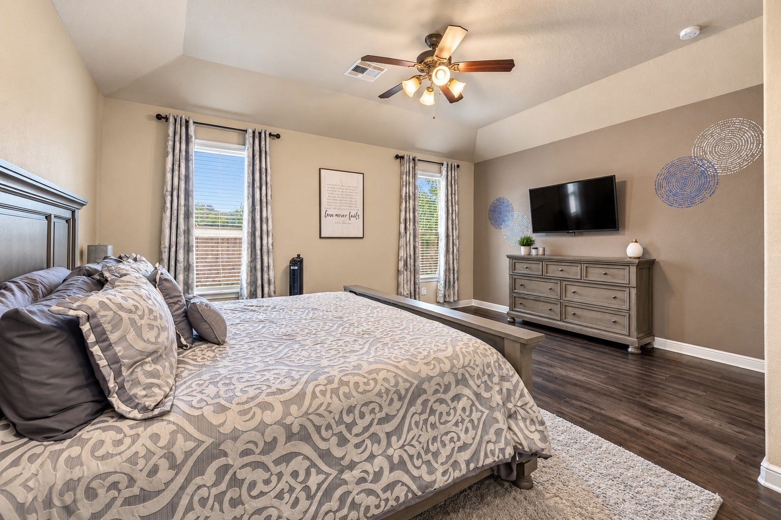 The primary retreat! Elegant flooring and vaulted ceilings elevate the vibe here and there's even space for a cozy seating area!