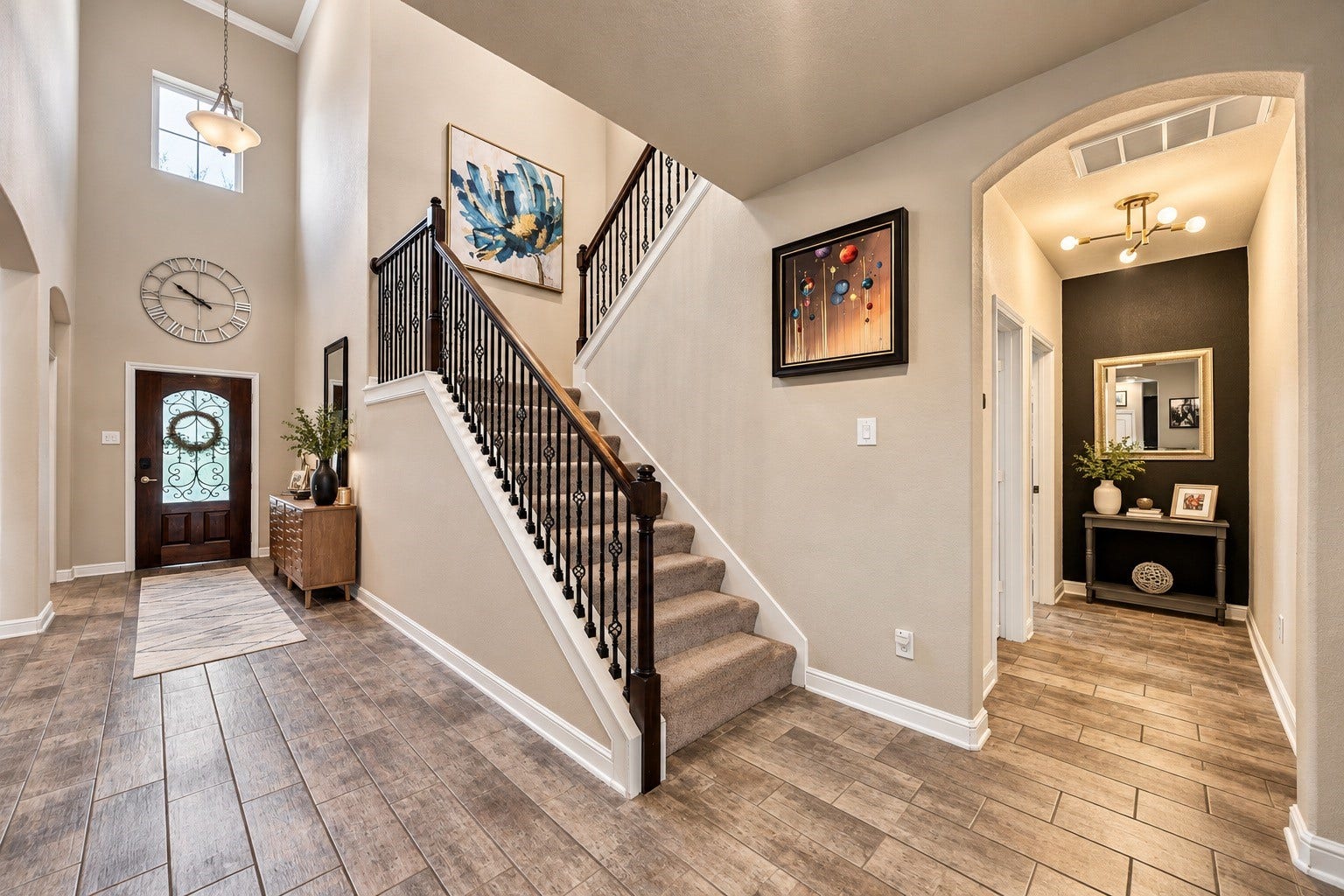 You're greeted with over 20 ft ceilings, upgraded tile flooring, and a stairway adorned with wrought iron railing, making a statement upon entry!