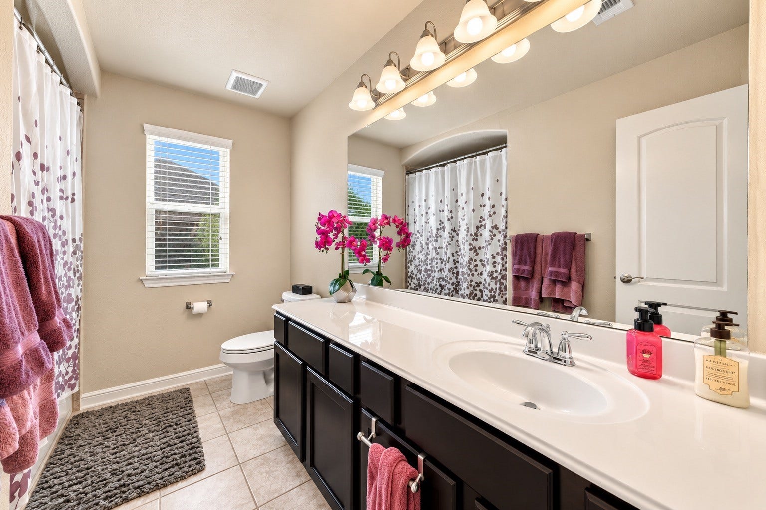 A bright and inviting secondary bathroom with ample counter space and beautiful tile foors!
