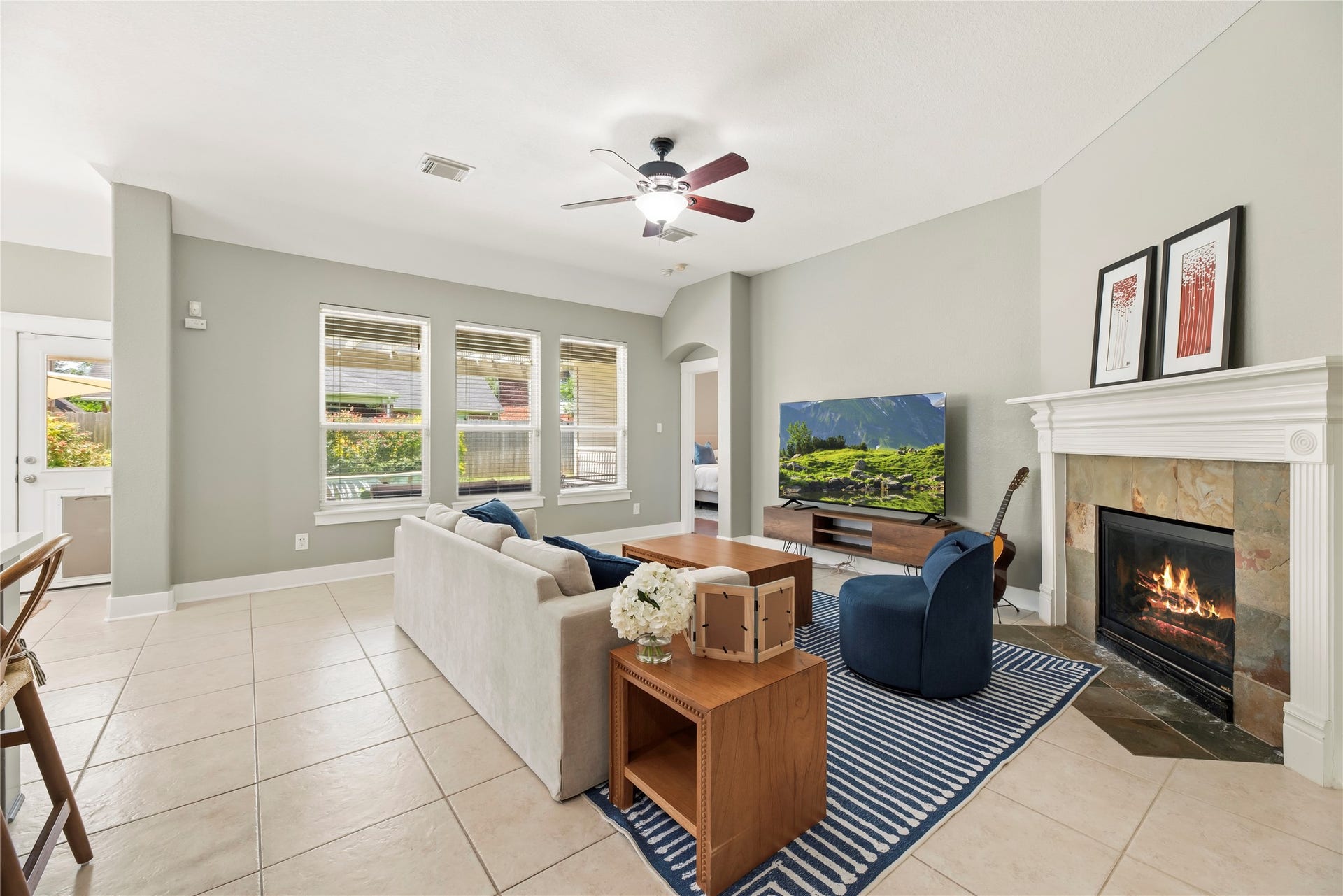 20918 Field Manor Lane, Katy, TX 77450 The inviting living room features a beautiful fireplace and a wall of windows with views of the pool.
