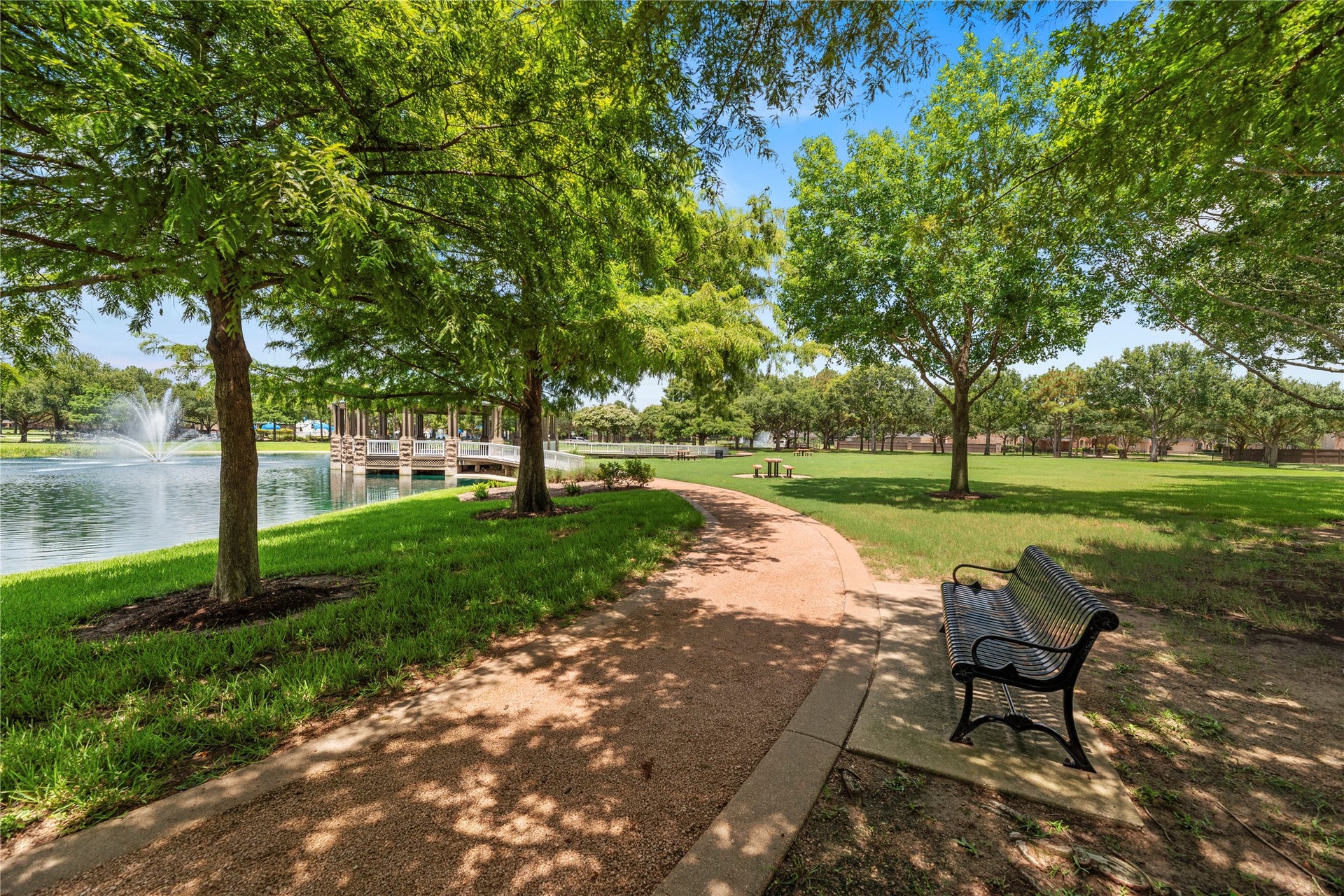 20918 Field Manor Lane, Katy, TX 77450 Serene park setting with a picturesque pond, charming fountain, and a shaded walking path perfect for relaxation and leisurely strolls.
