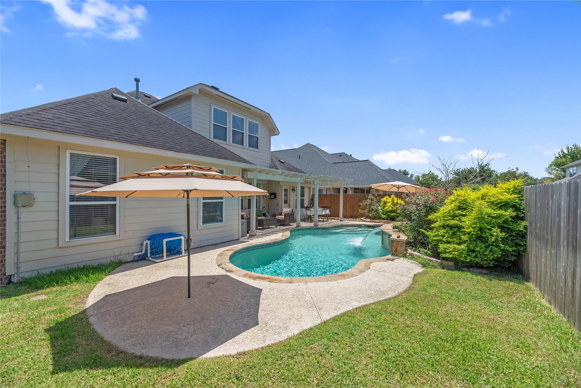 20918 Field Manor Lane, Katy, TX 77450 Private backyard retreat with a sparkling pool, covered patio, mature landscaping, and plenty of space to relax or entertain.