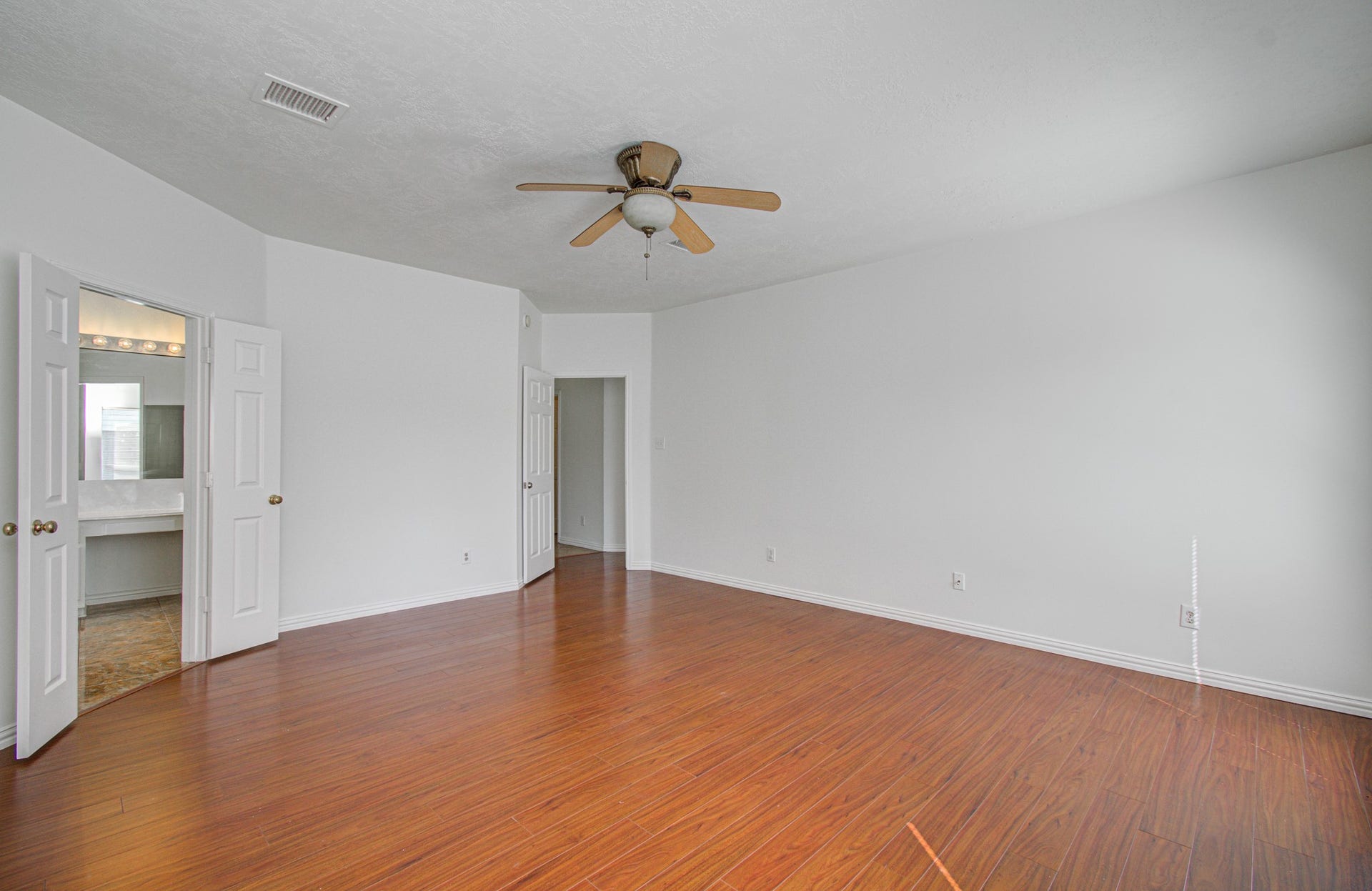 1402 Pine Knot Court, Pearland, TX 77581 Primary bedroom. Entry door on the right. Doors on left lead to primary bath.
