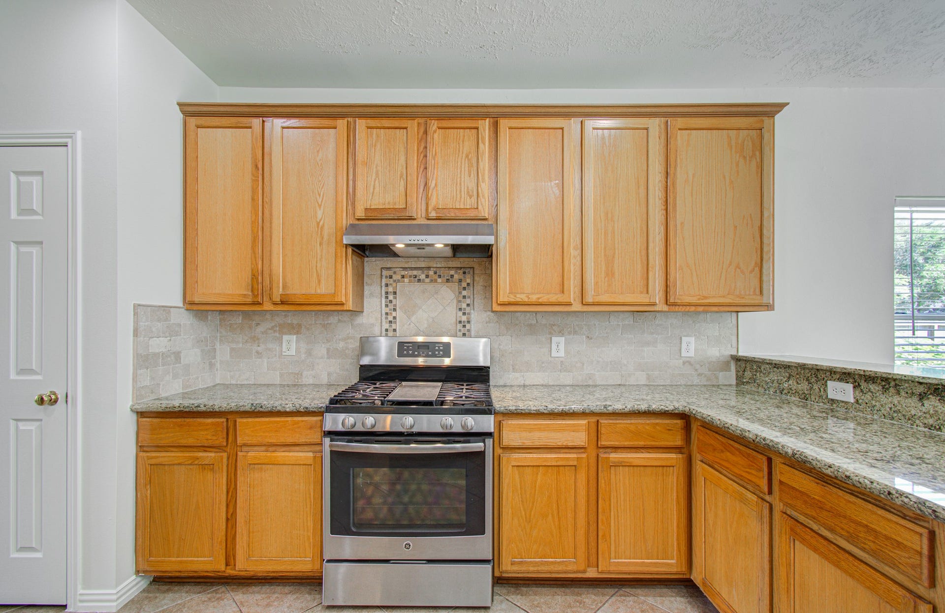 1402 Pine Knot Court, Pearland, TX 77581 Traditional wood cabinetry, ample countertop space, and gas cooktop.