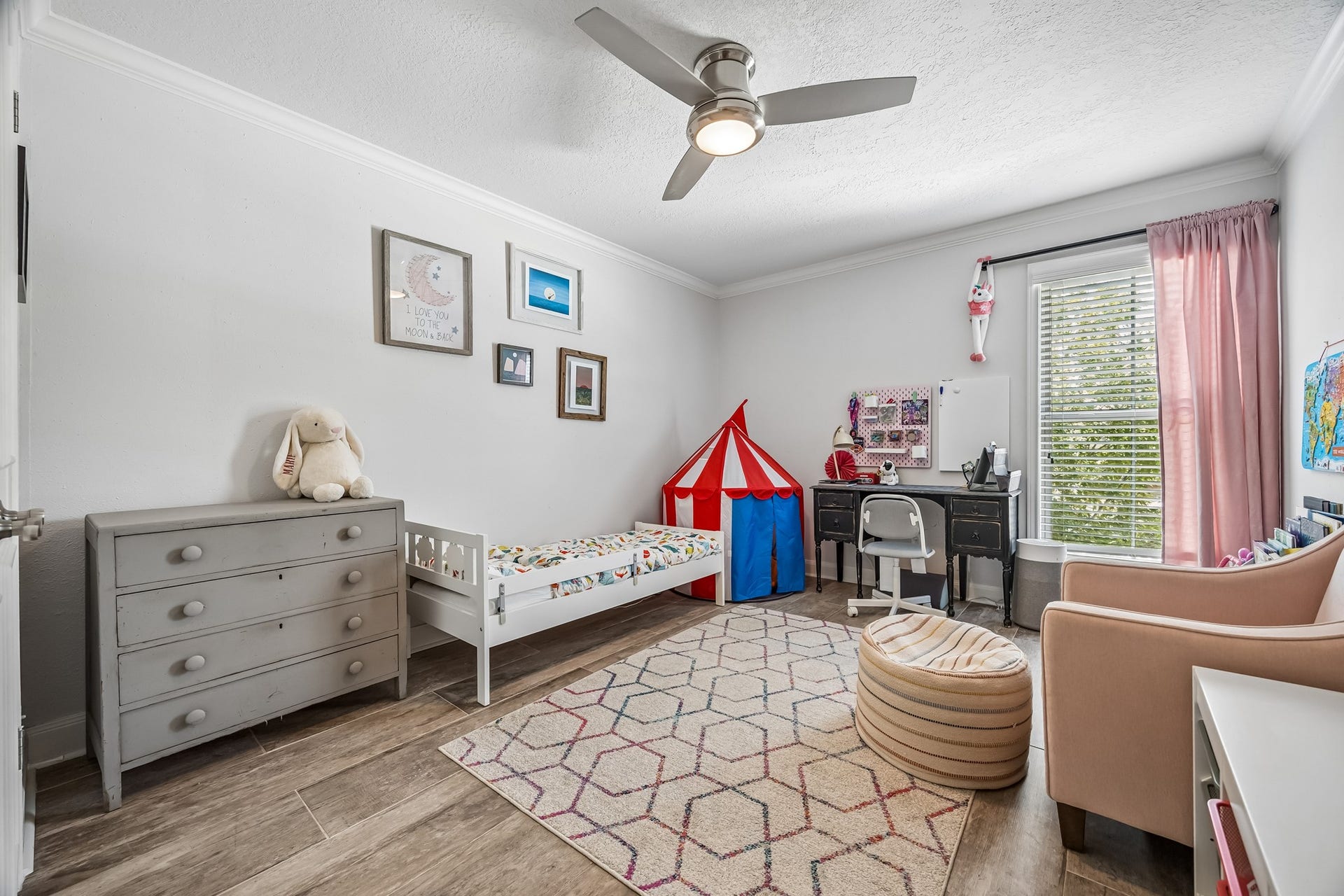 14719 Barryknoll Lane, #51, Houston, TX 77079 This secondary bedroom offers a spacious layout with wood-look flooring, crown molding, and a ceiling fan. The large window brings in natural light, making the room comfortable for a bedroom, playroom, or study space.