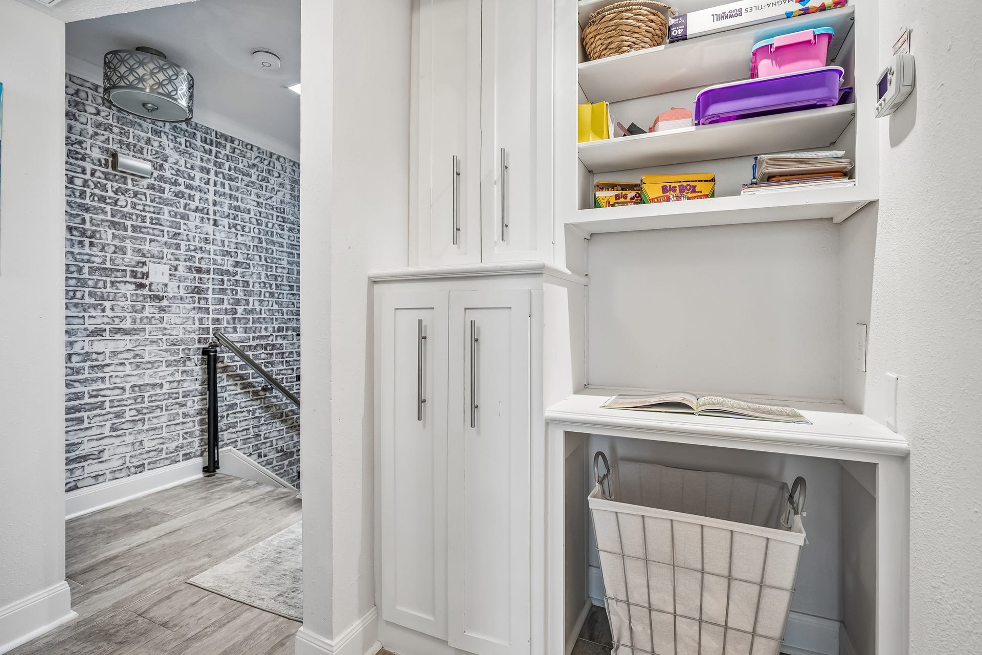 14719 Barryknoll Lane, #51, Houston, TX 77079 Built-in cabinetry and open shelving provide practical storage just outside the bedroom area. The nearby stair landing keeps household essentials organized while maintaining a clean, finished look.