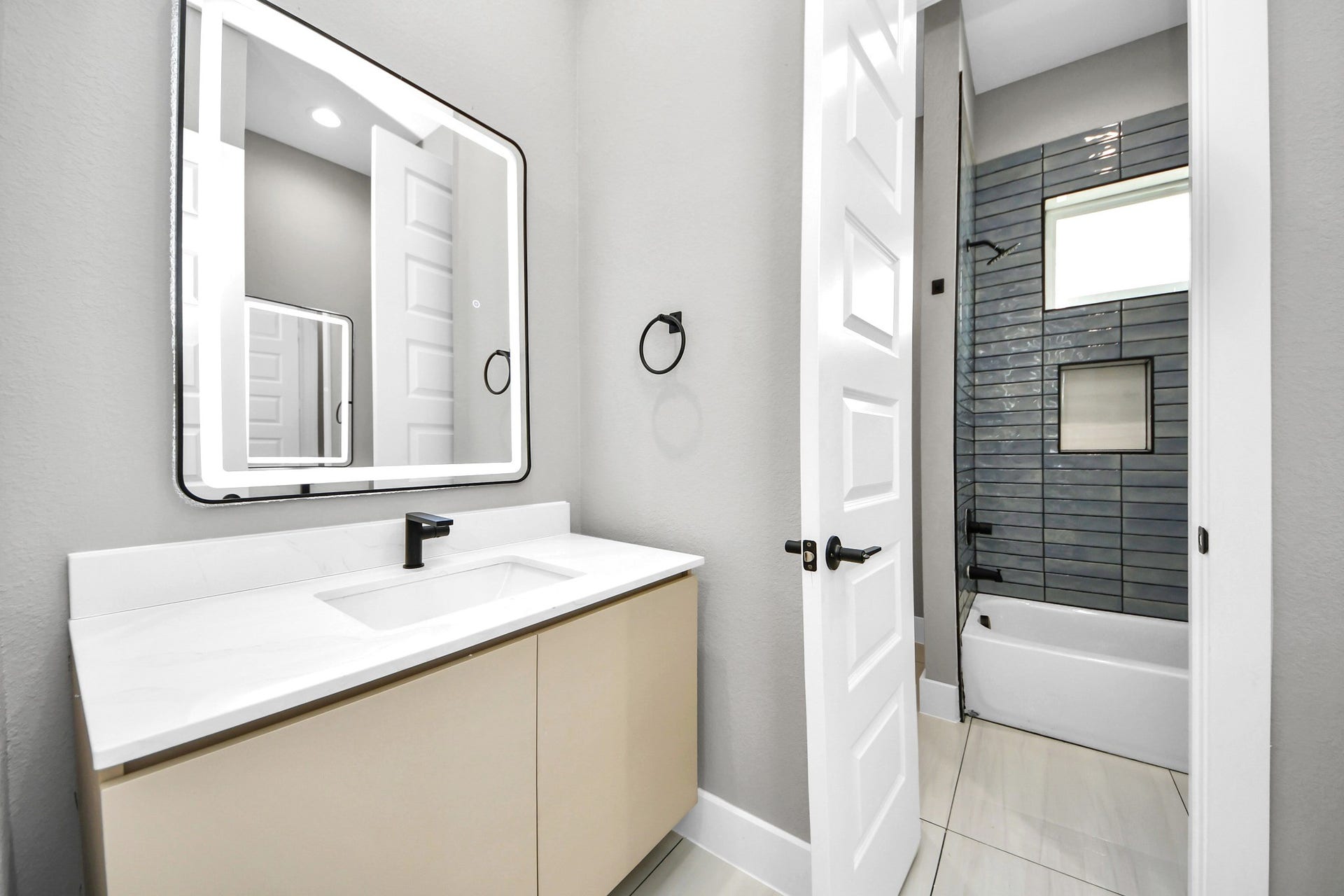 The stylish secondary bathroom continues the homes cohesive palette with crisp, contemporary finishes.