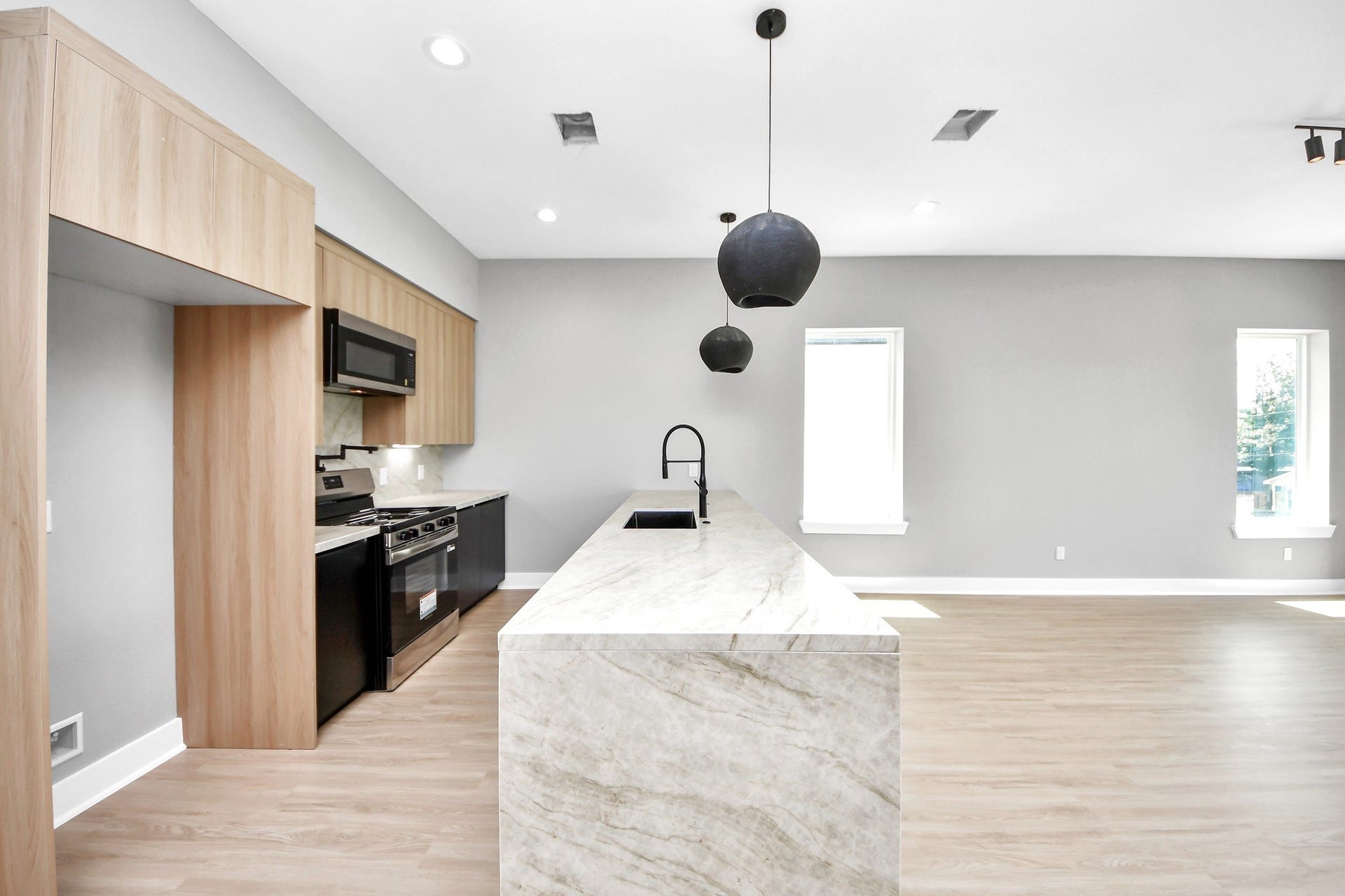 A dramatic waterfall-edge island anchors Unit Cs designer kitchen and creates an effortless gathering space.