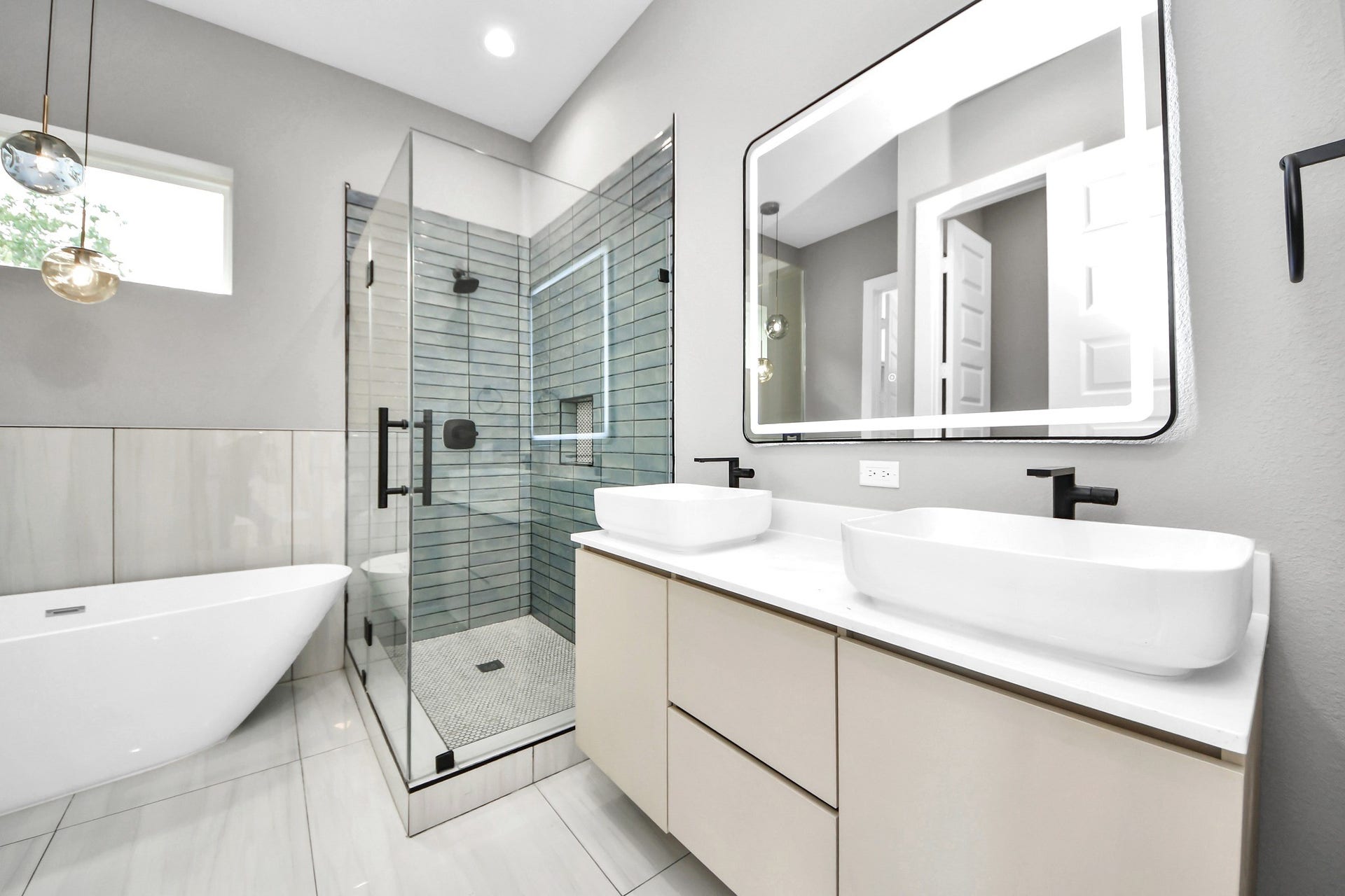 A bright primary bathroom combines clean modern finishes, generous storage and a spa-inspired atmosphere.