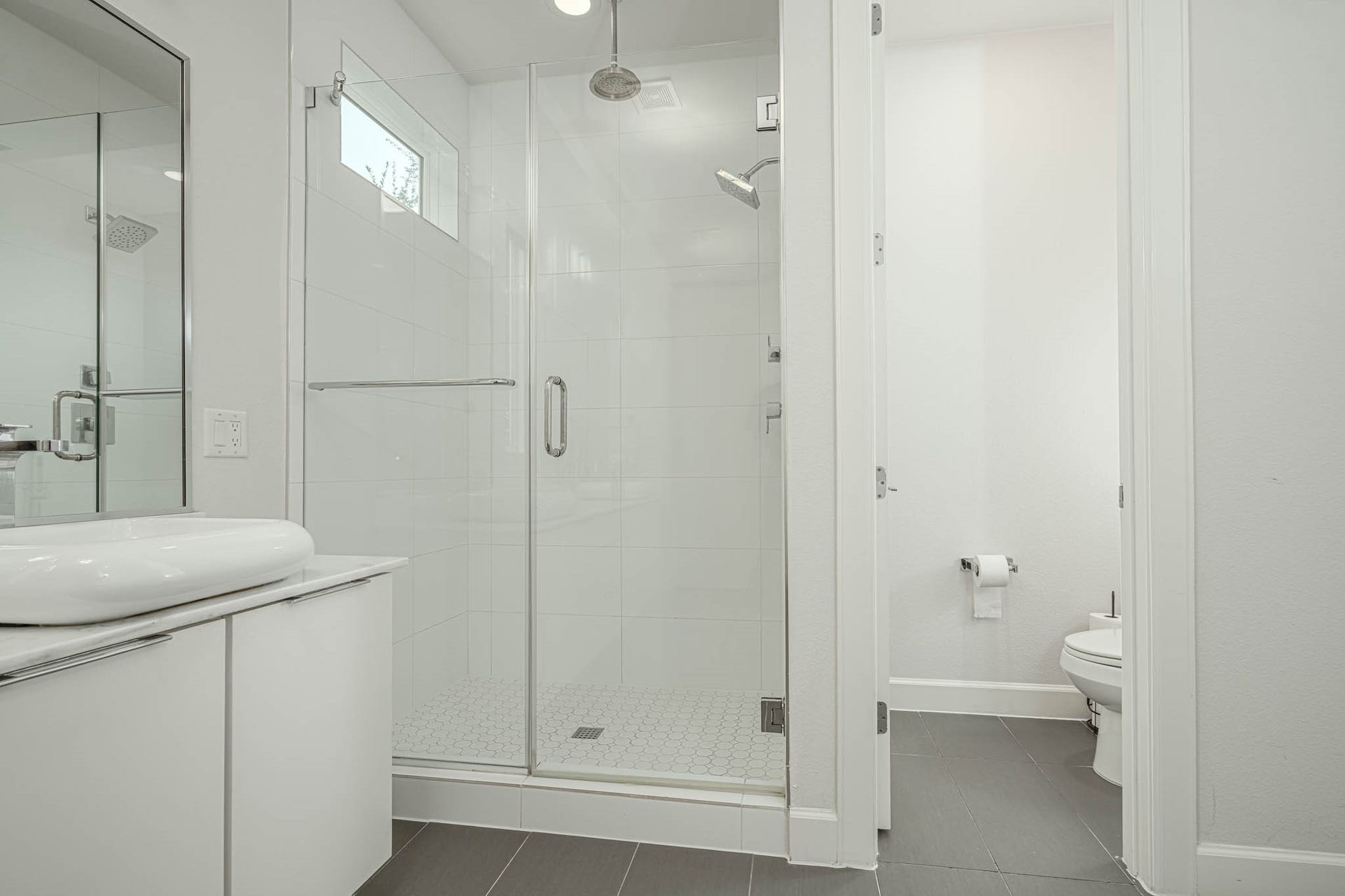 1615 Bingham Street, Houston, TX 77007 Sleek and modern bathroom featuring a spacious glass-enclosed shower, elegant vanity, and a separate toilet area for added privacy.