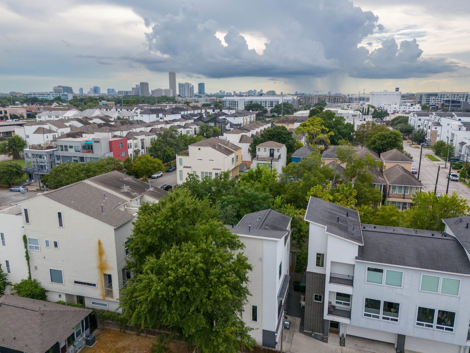 1615 Bingham Street, Houston, TX 77007 Modern townhomes nestled in a vibrant neighborhood, surrounded by lush greenery and offering a stunning skyline view.
