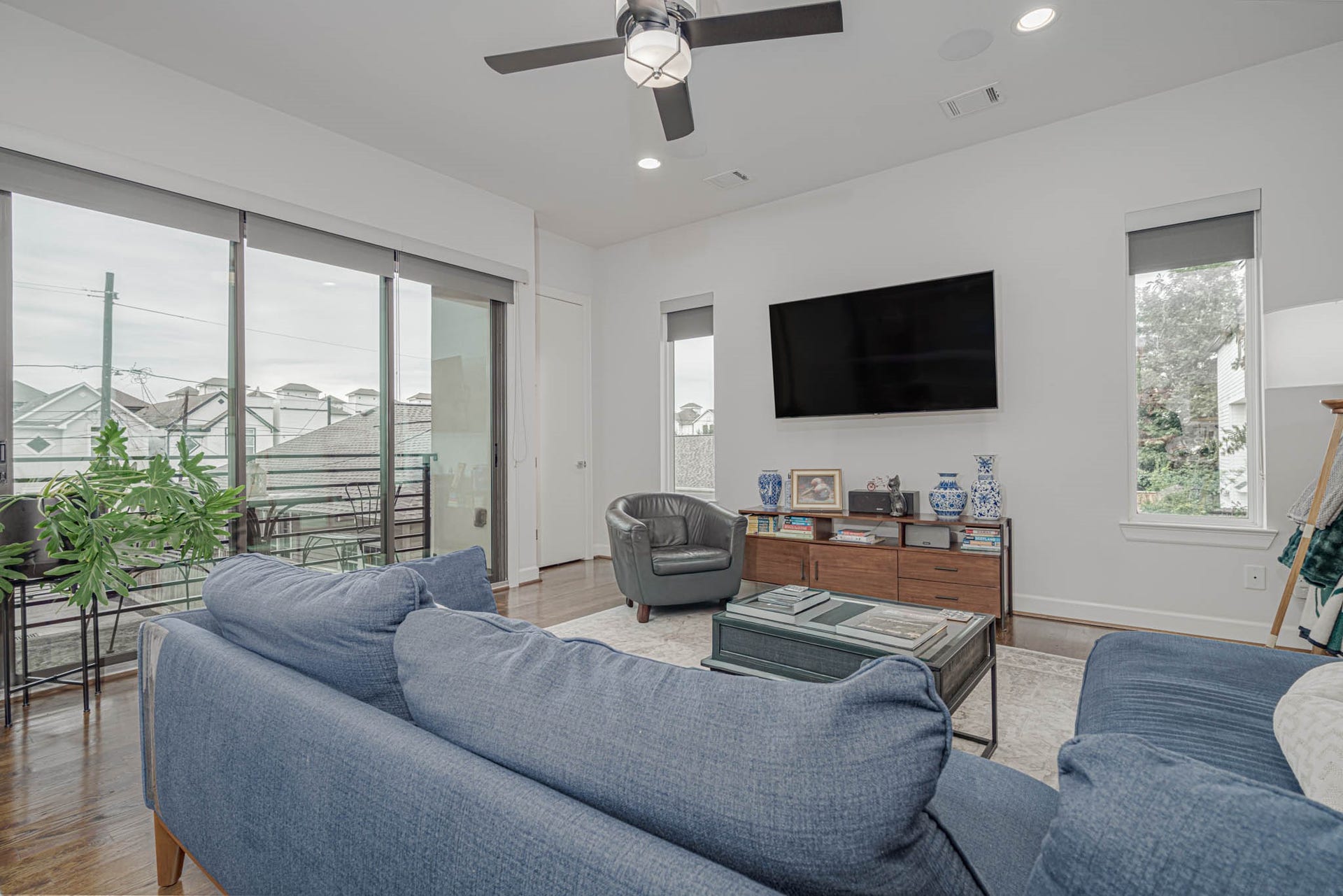 1615 Bingham Street, Houston, TX 77007 Bright and inviting living area with a modern ceiling fan, large windows offering natural light, and a cozy seating arrangement, perfect for relaxation and entertainment.