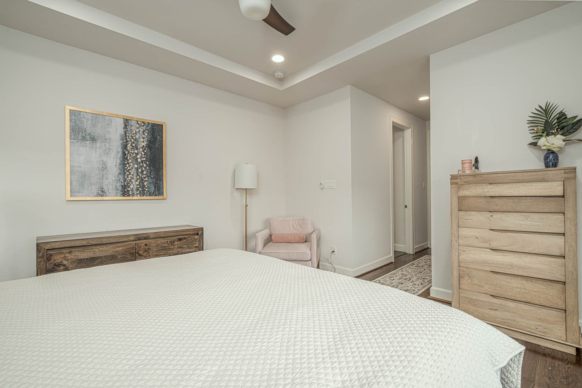 1615 Bingham Street, Houston, TX 77007 Inviting bedroom featuring a cozy layout with soft neutral tones, a stylish ceiling fan, and ample natural light. The room includes elegant wood furniture and modern decor, creating a serene and comfortable retreat.